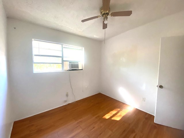 Secondary bedroom with ceiling fan and ac window unit.