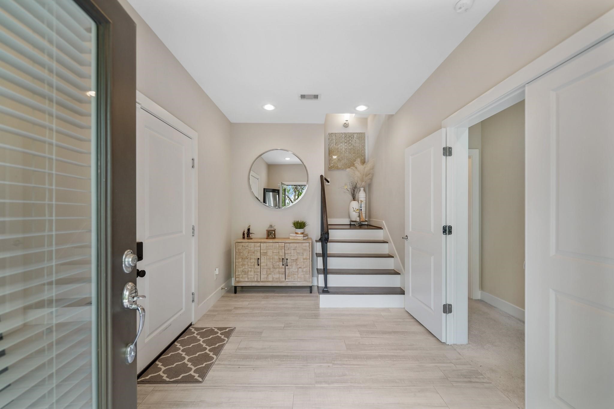 The foyer of the home has a high ceiling with recessed lighting, space for accent furniture & tile flooring. Included is a wrought iron staircase with hardwood treads leading to the second level of the home and access to the home's attached garage is provided just through the door on the left and includes an automated smart door lock. The foyer of the home has a high ceiling with recessed lighting, space for accent furniture & tile flooring. Included is a wrought iron staircase with hardwood treads leading to the second level of the home and access to the home's attached garage is provided just through the door on the left and includes an automated smart door lock.