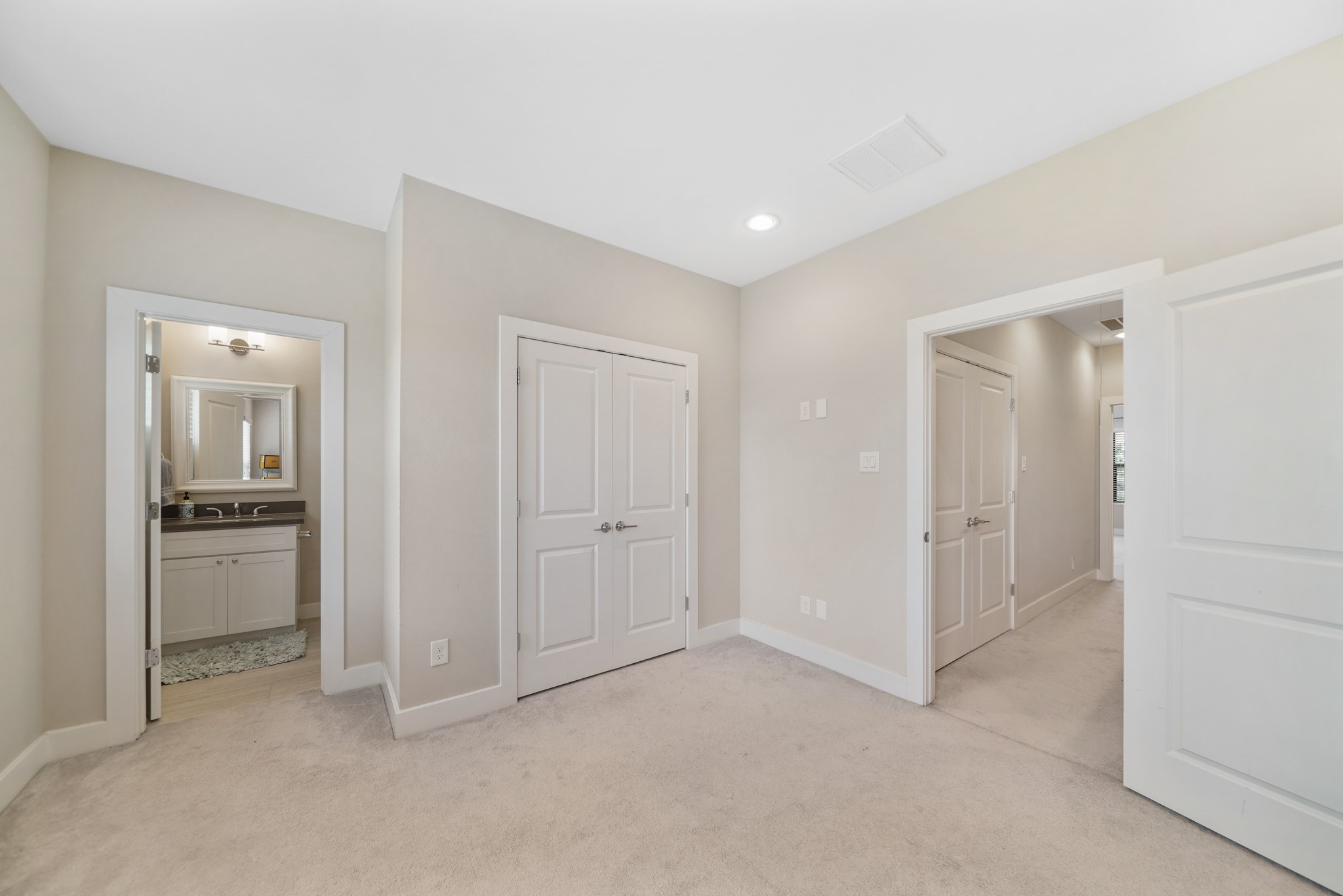A view of the second bedroom with access to the ensuite bath on the left.