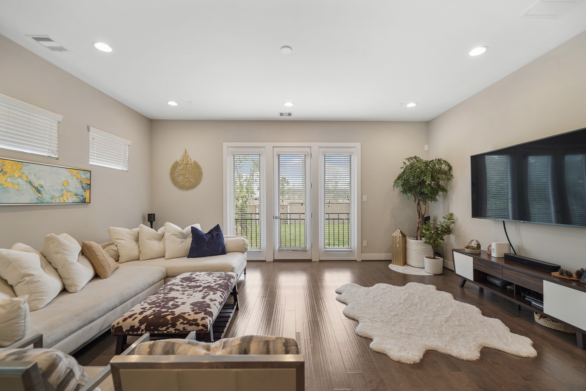 Upper fixed glass windows with blinds provide additional natural light in this spaciously designed living room. Upper fixed glass windows with blinds provide additional natural light in this spaciously designed living room.