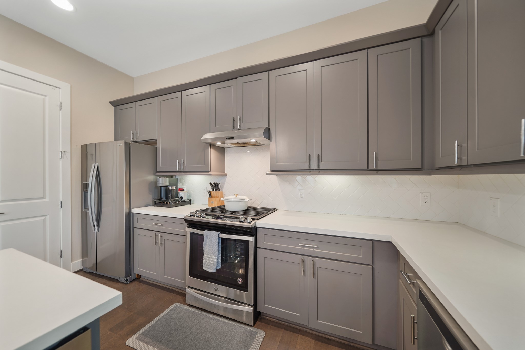 The Whirlpool stainless steel appliance package includes a 5- burner gas range with a combination conventional/convection oven below and stainless steel ventilation hood with lighting above, built-in microwave oven and a dishwasher. Move-in
ready, the stainless steel side-by-side refrigerator/freezer with door mounted ice & water dispenser remains with the home.