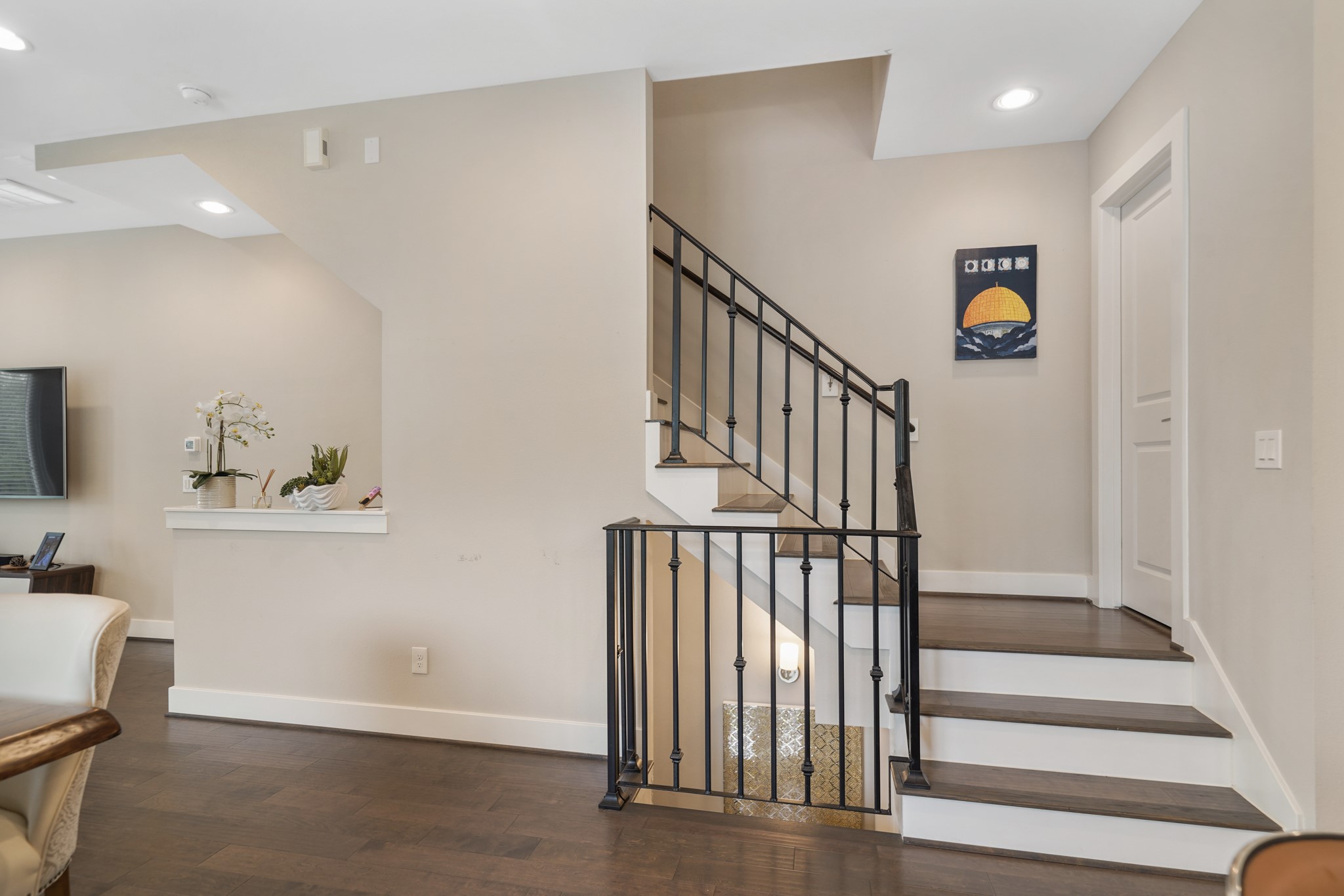 A wrought iron staircase leads to the third level of the home with a half bath accessible through the door on the right.