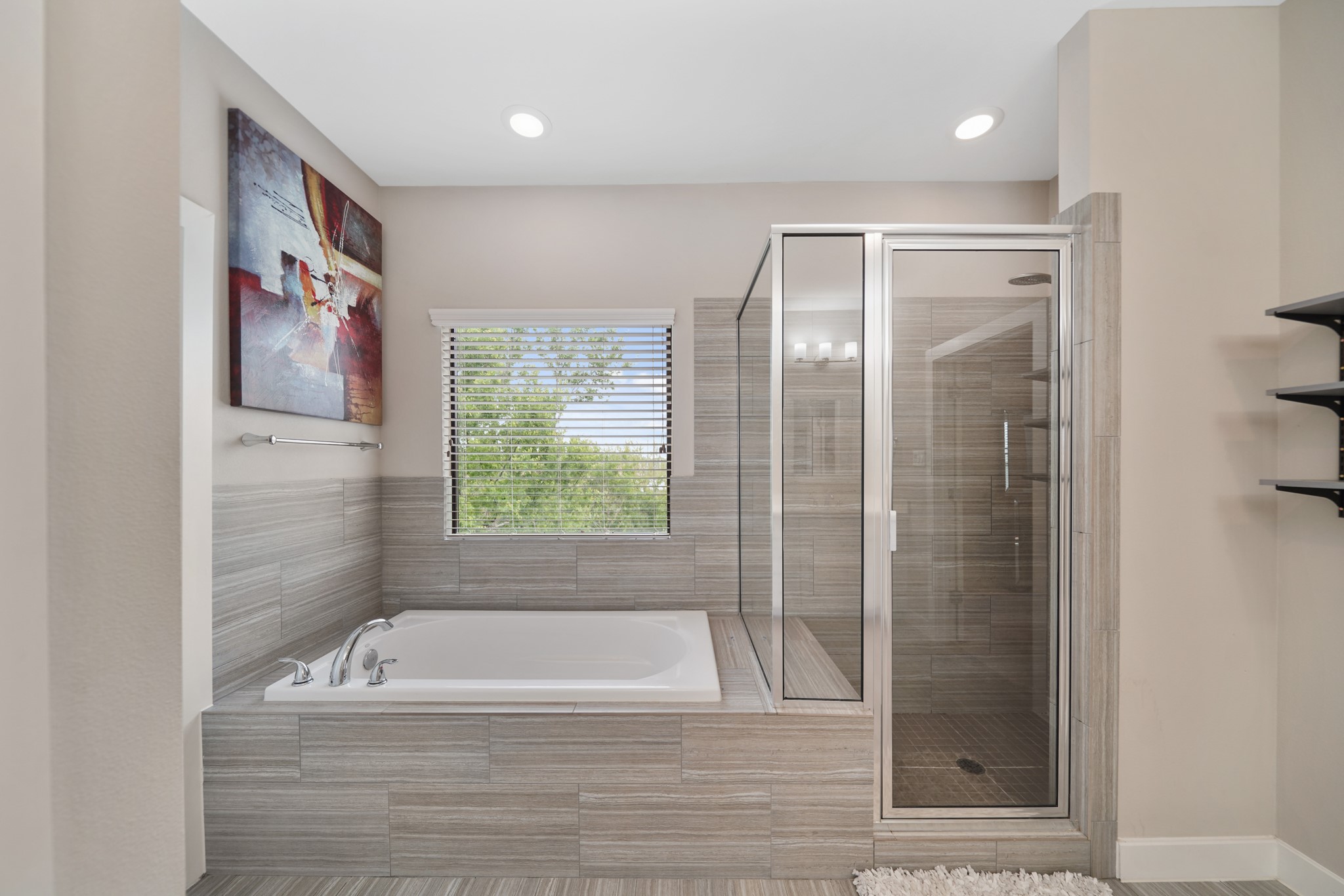 Relax & unwind in the tile surrounded soaking tub with window & blinds above and nearby tile surrounded glass enclosed walk-in shower with seating.