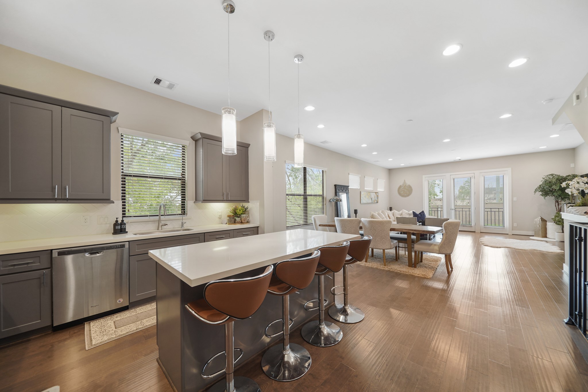 One last view of the kitchen with the dining & living rooms in the background. As an added bonus, the landlord is willing to leave the four bar stools.