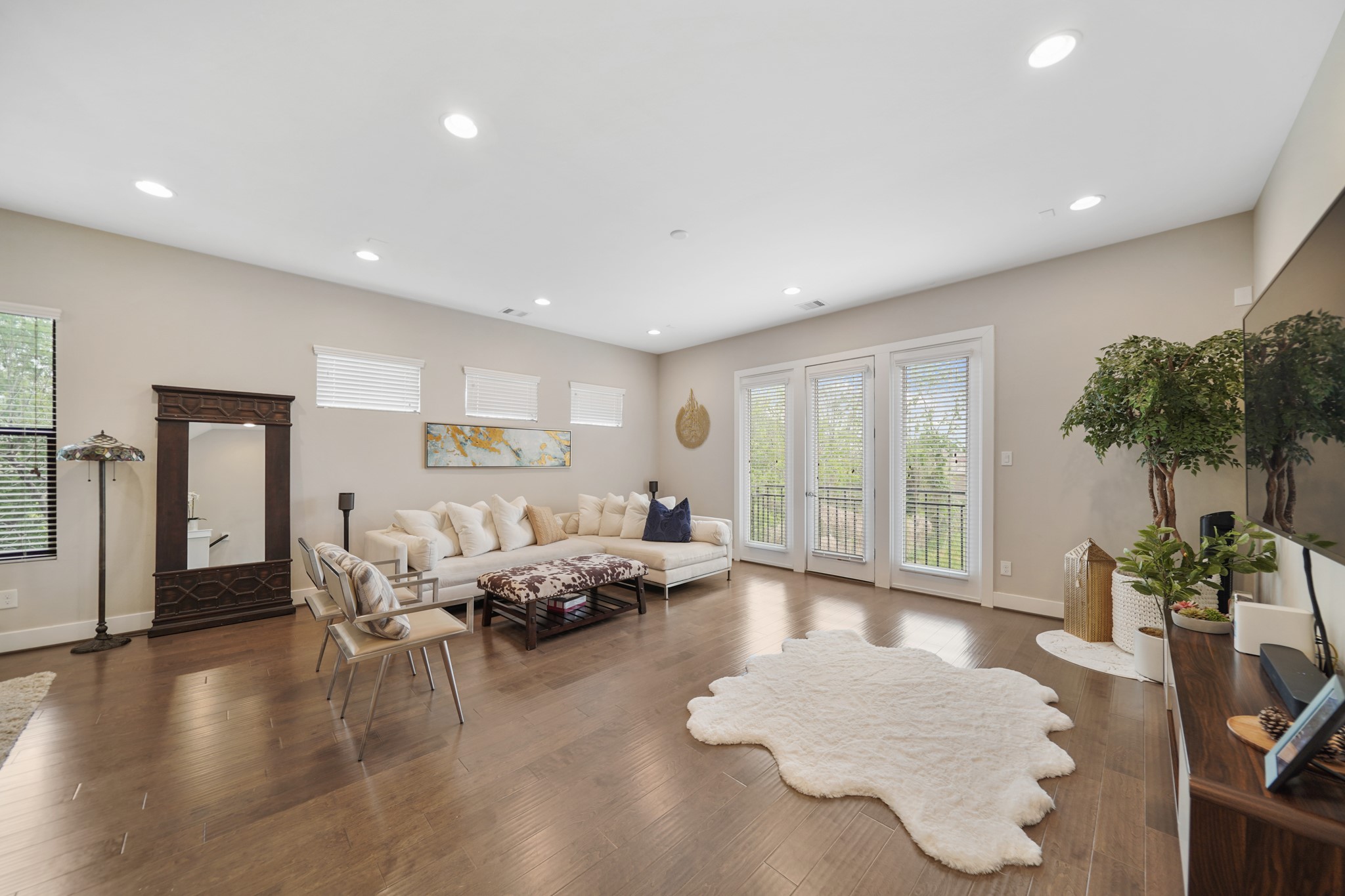 The living room with a high ceiling, recessed lighting & surround sound speaker pre-wiring includes gleaming hardwood floors. The living room with a high ceiling, recessed lighting & surround sound speaker pre-wiring includes gleaming hardwood floors.
