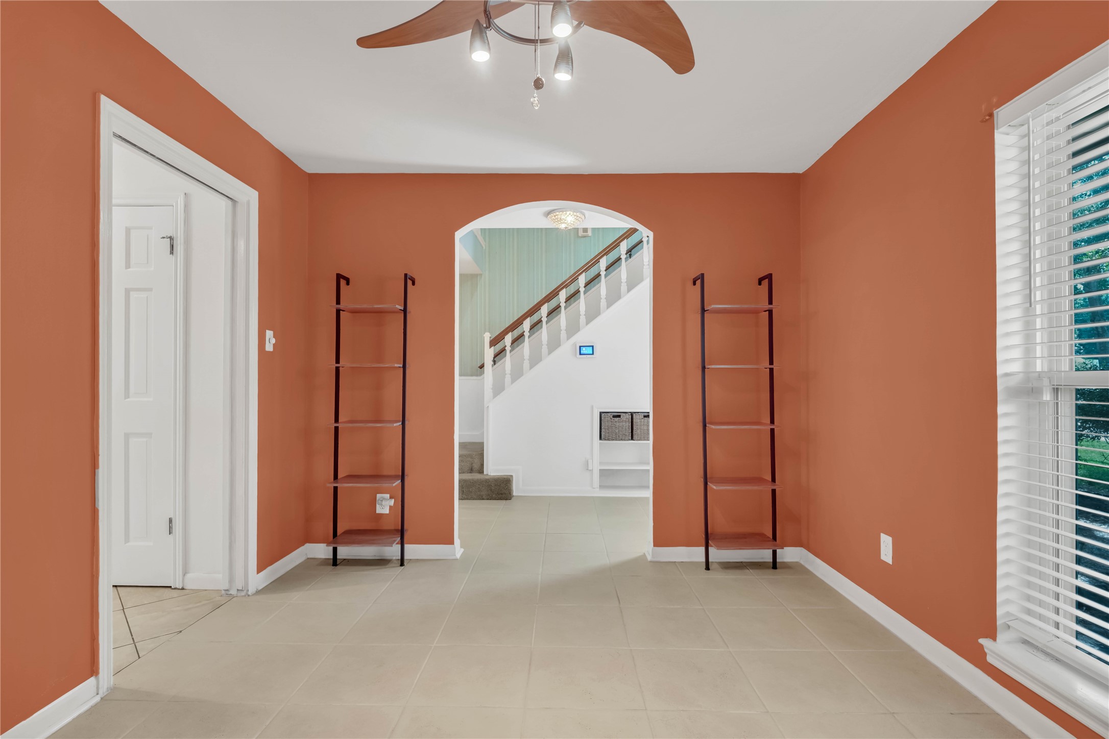Another view of the formal dining room highlighting its generous proportions, natural light, and graceful arched entryway.