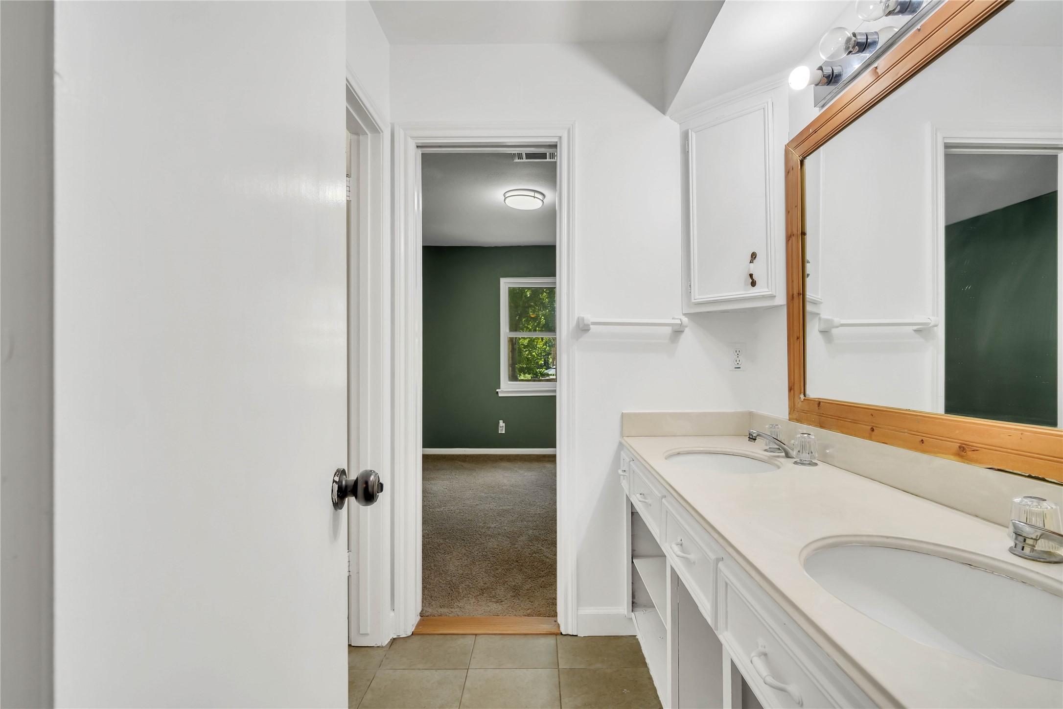 Additional view of the Jack-and-Jill bathroom highlighting the extended vanity and convenient access between both upstairs bedrooms.