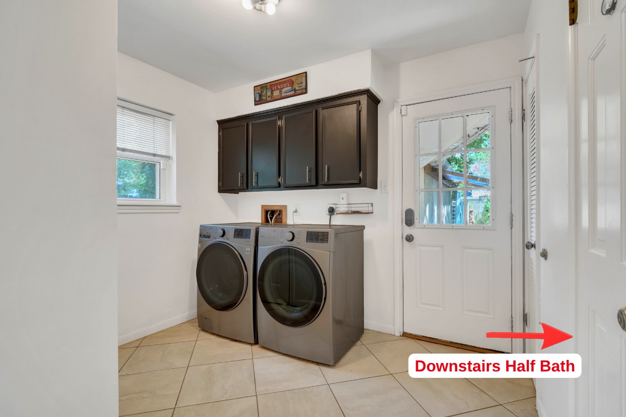 Dedicated laundry room featuring built-in cabinetry for added storage and convenient direct access to the backyard.
