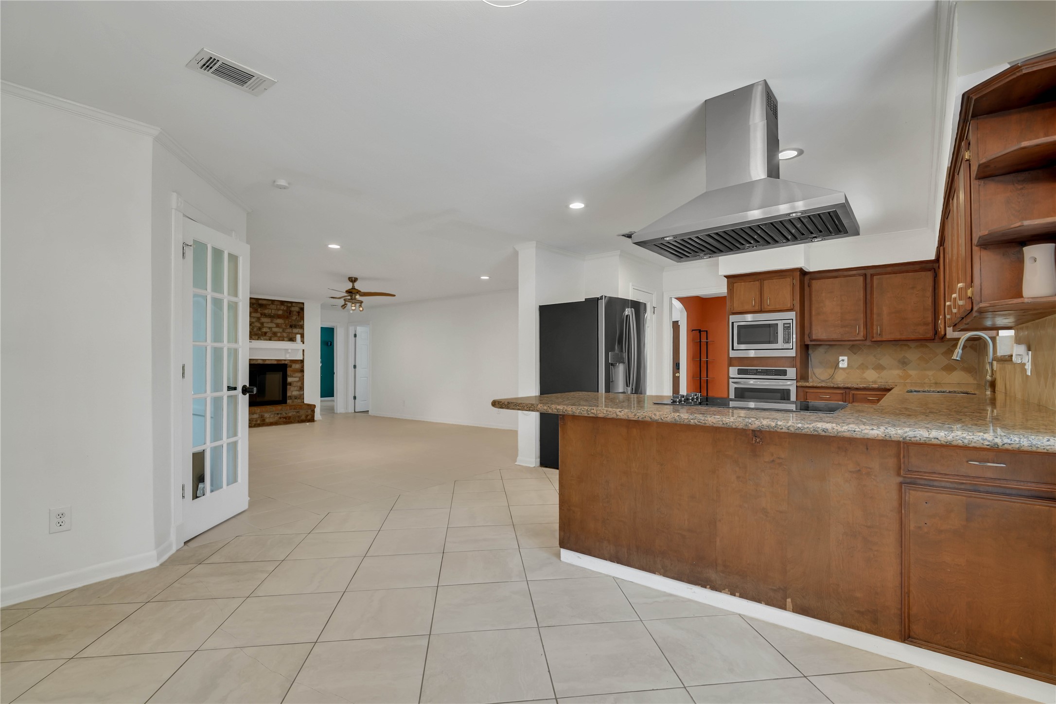 An inviting view from the breakfast area captures the homes impressive flow, with the living room extending ahead, the sunroom positioned to the left, and the kitchen anchoring the space to the right.