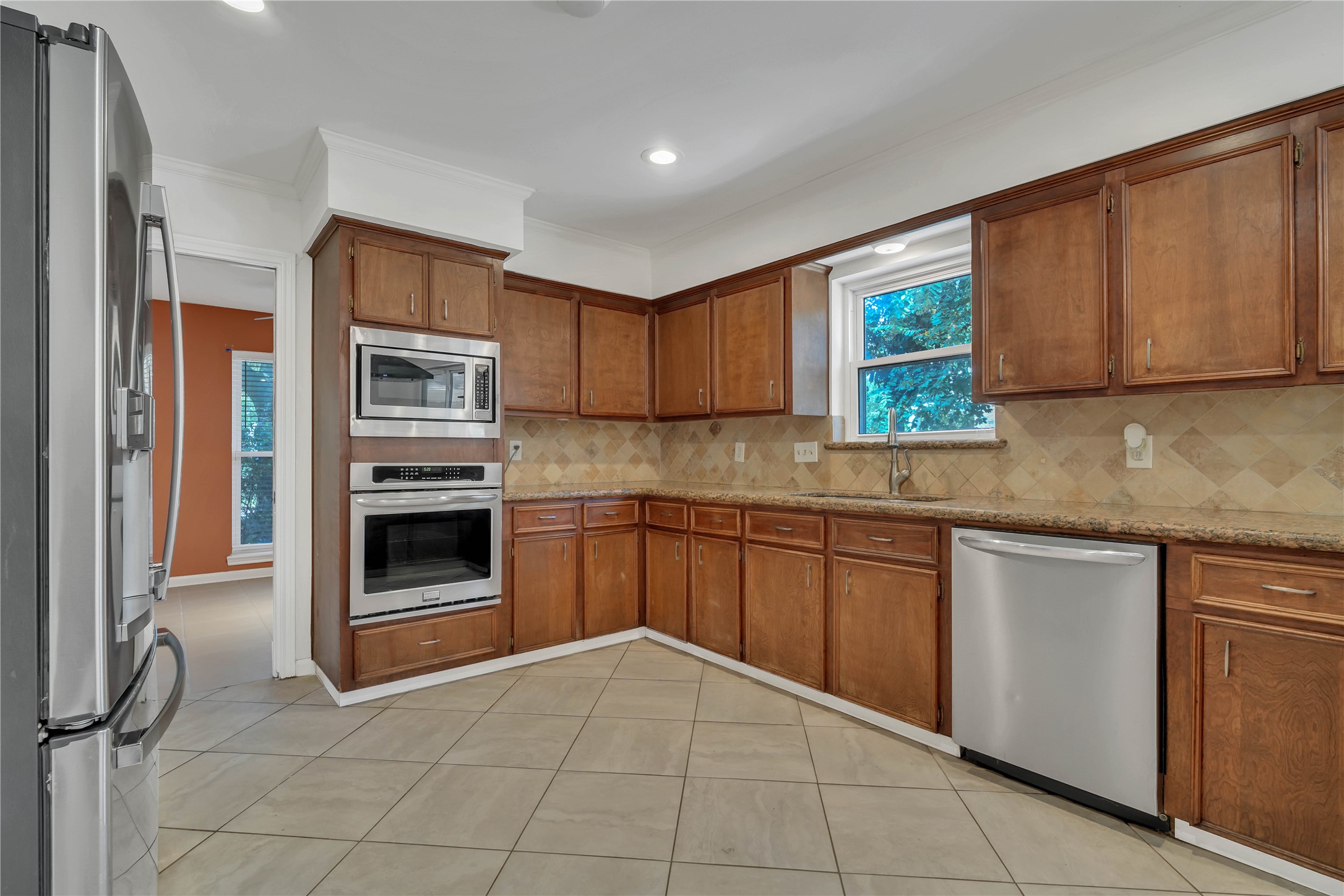 Another perspective highlighting the granite countertops, extensive cabinetry, and built-in double ovens.