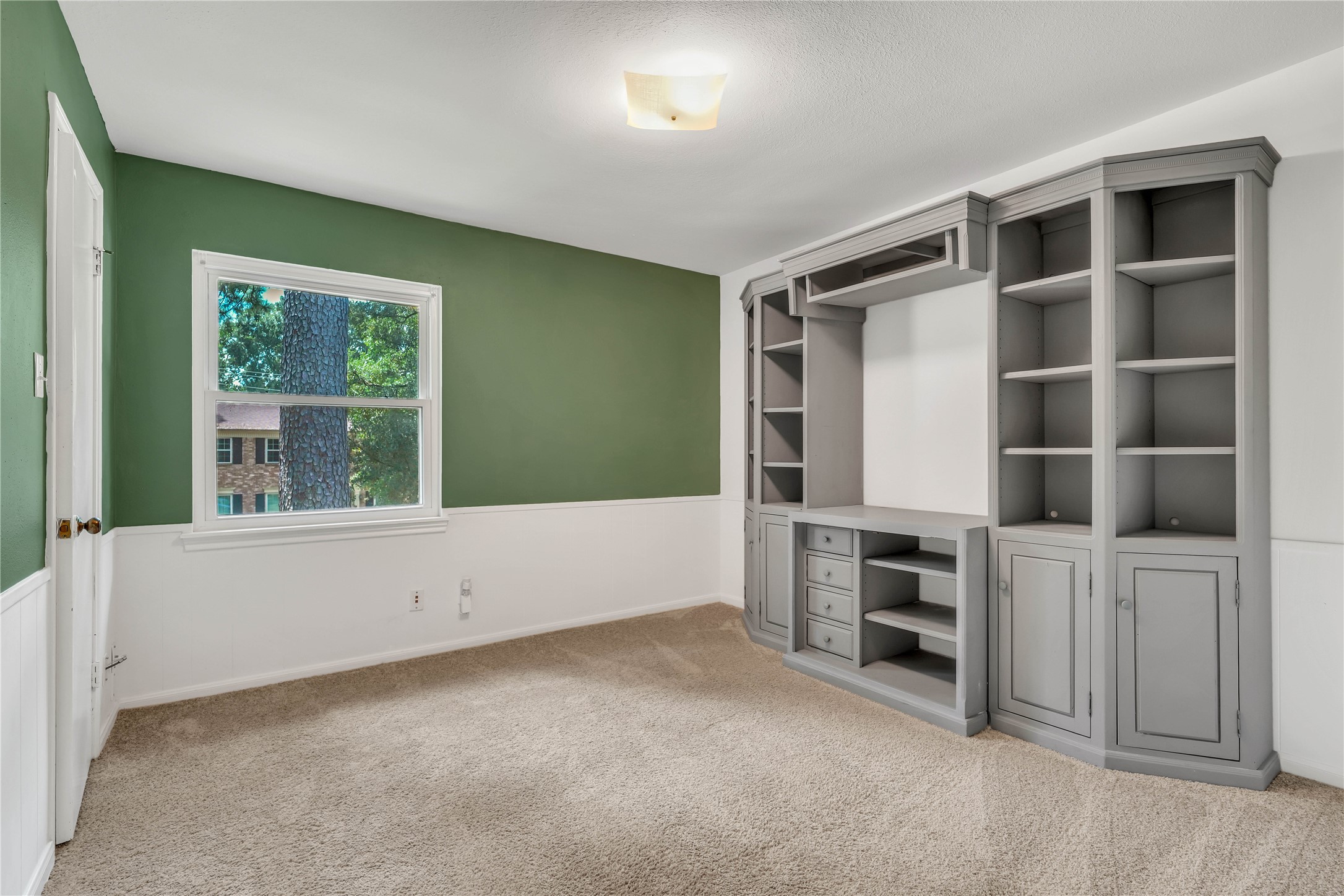Upstairs bedroom featuring generous proportions, natural light, and impressive built-in cabinetry and shelving for added character and functionality.
