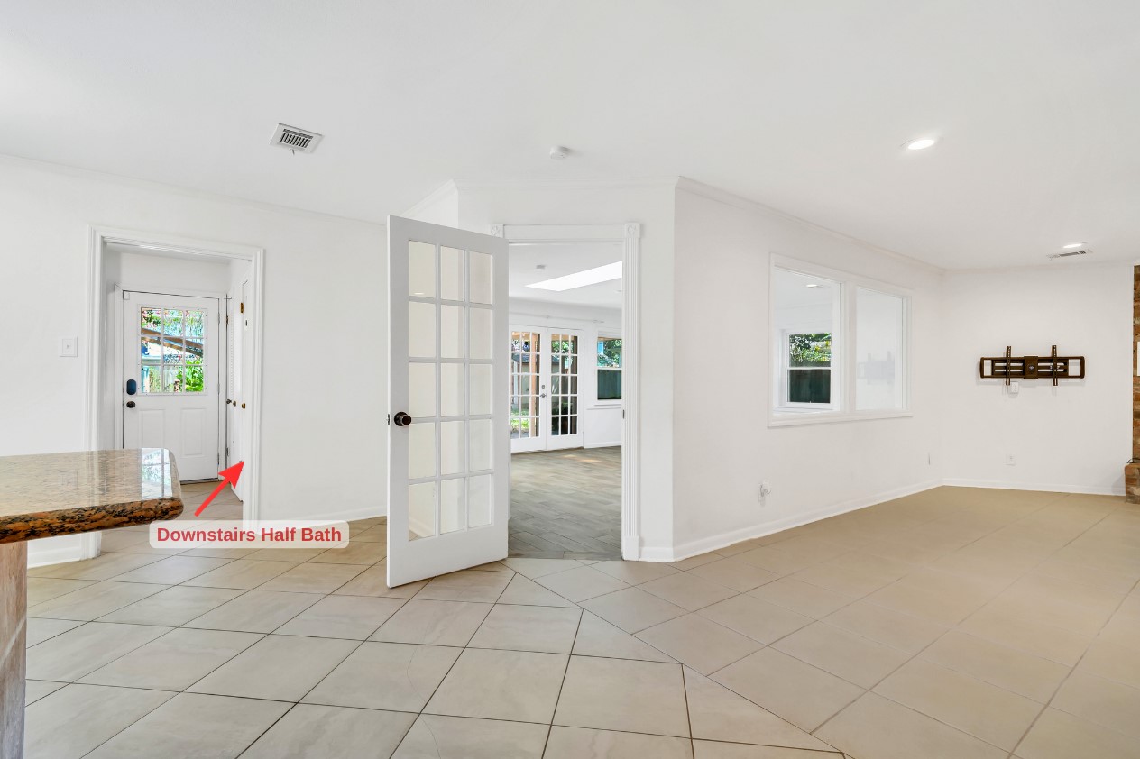 View from the kitchen showcases the expansive living room and its inviting connection to the sunroom beyond, creating an impressive layout for entertaining and everyday living.