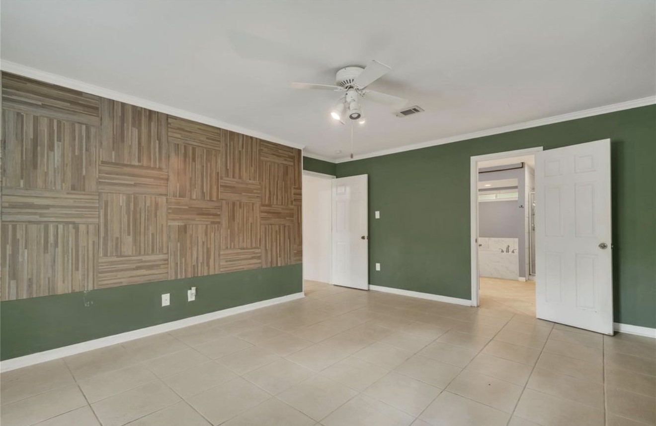 This perspective highlights the primary bedrooms distinctive accent wall and direct access to the private primary bath.