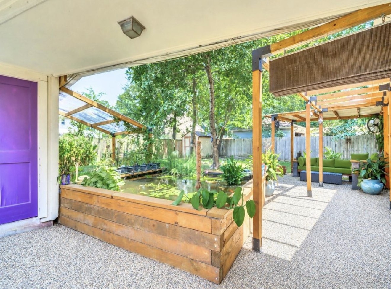 Backyard view highlighting the detached garage alongside a unique non-chemical pond with goldfish, mosquito fish, and koi, supported by a pressurized filtration system.