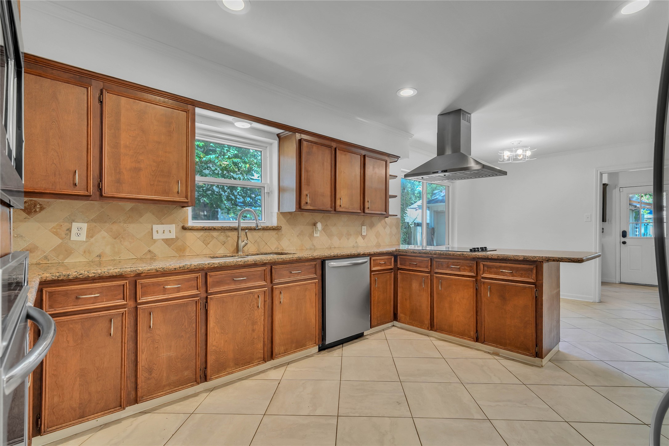 Spacious kitchen showcasing granite countertops, abundant cabinetry, and a large peninsula ideal for meal preparation and casual gathering.