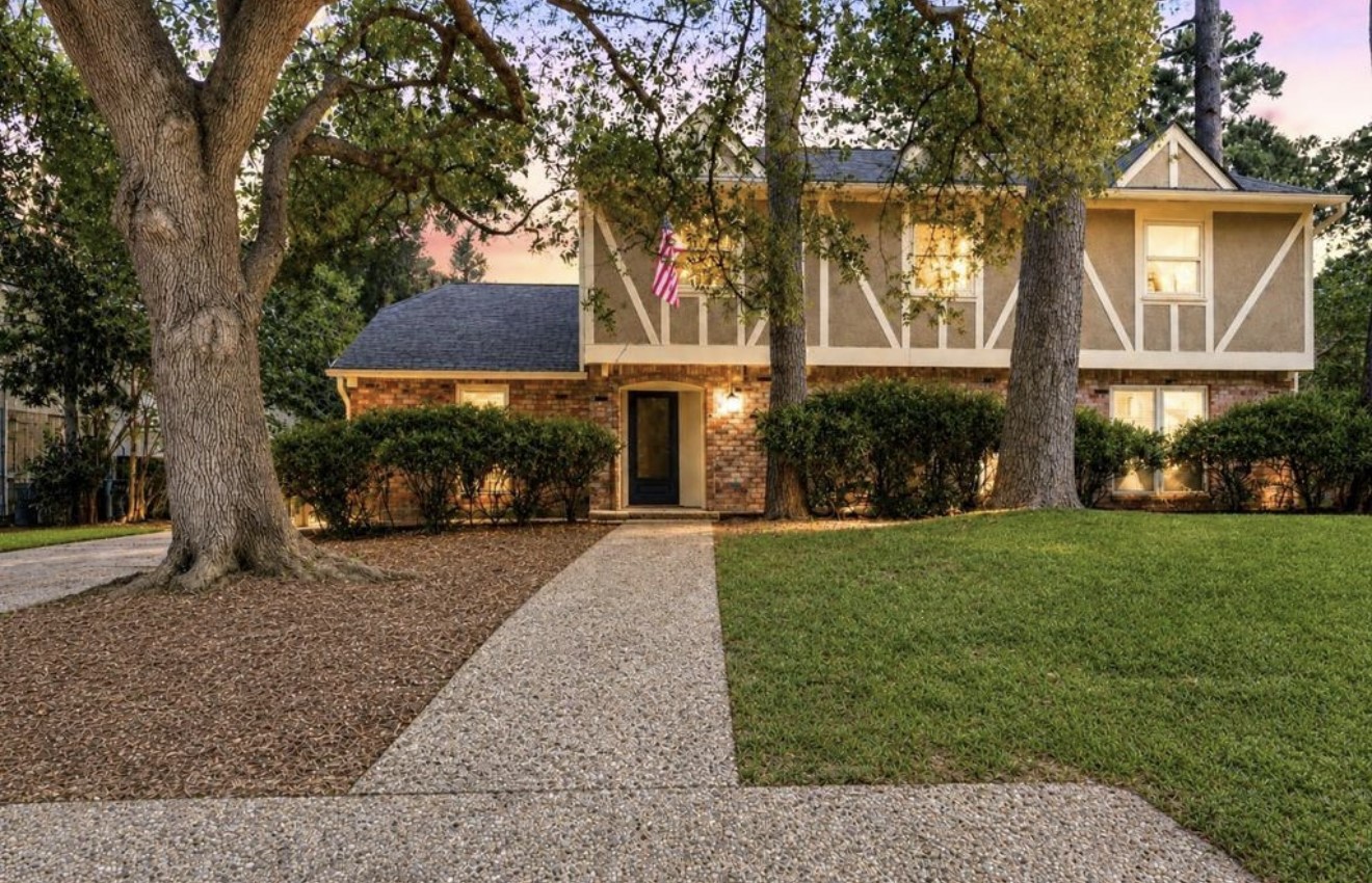 Inviting front exterior showcasing the homes distinctive two-story architecture, mature trees, and established Norchester setting.
