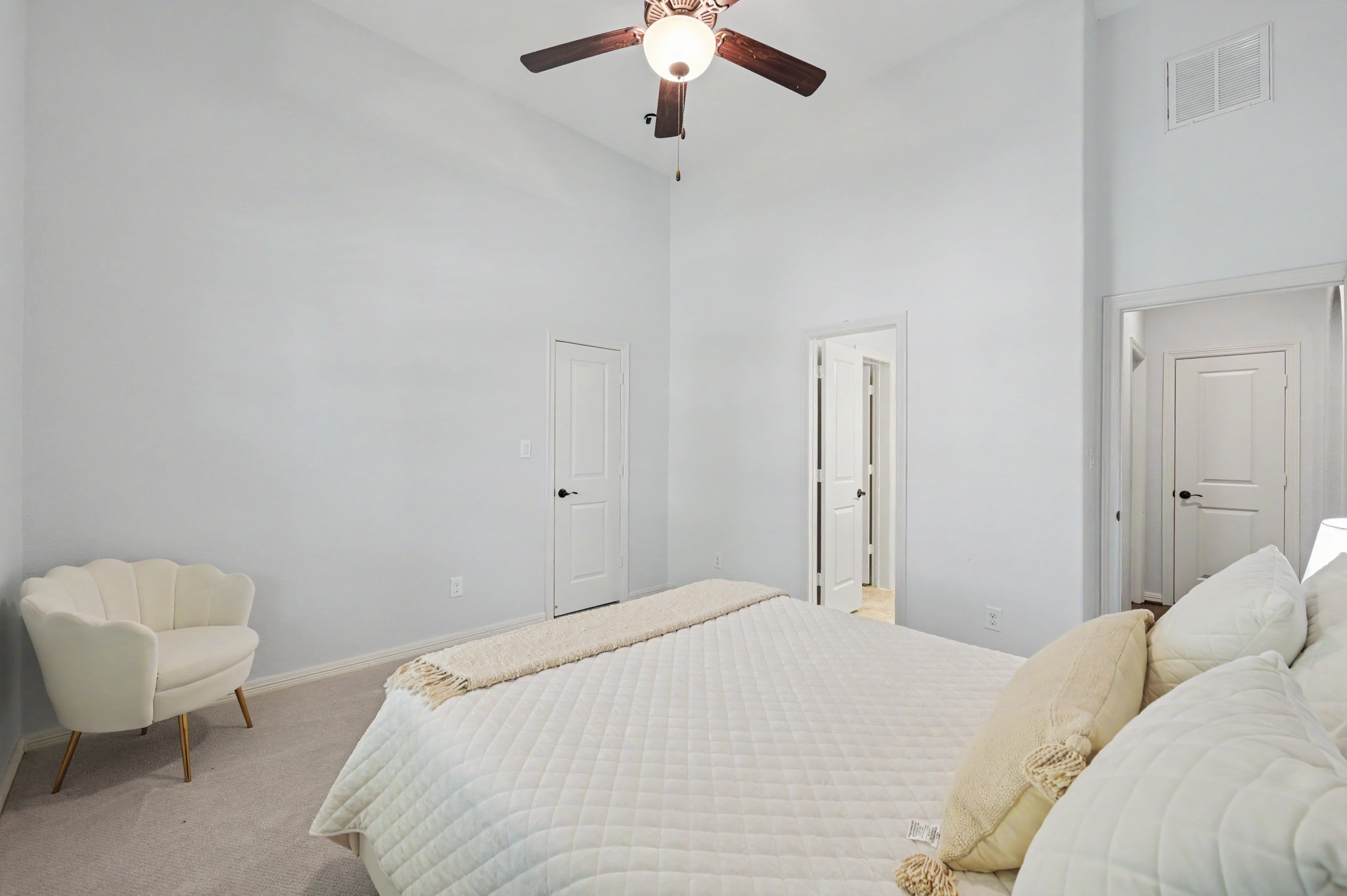 Bright and spacious bedroom featuring a vaulted ceiling, modern ceiling fan, and soft neutral tones for a serene atmosphere.