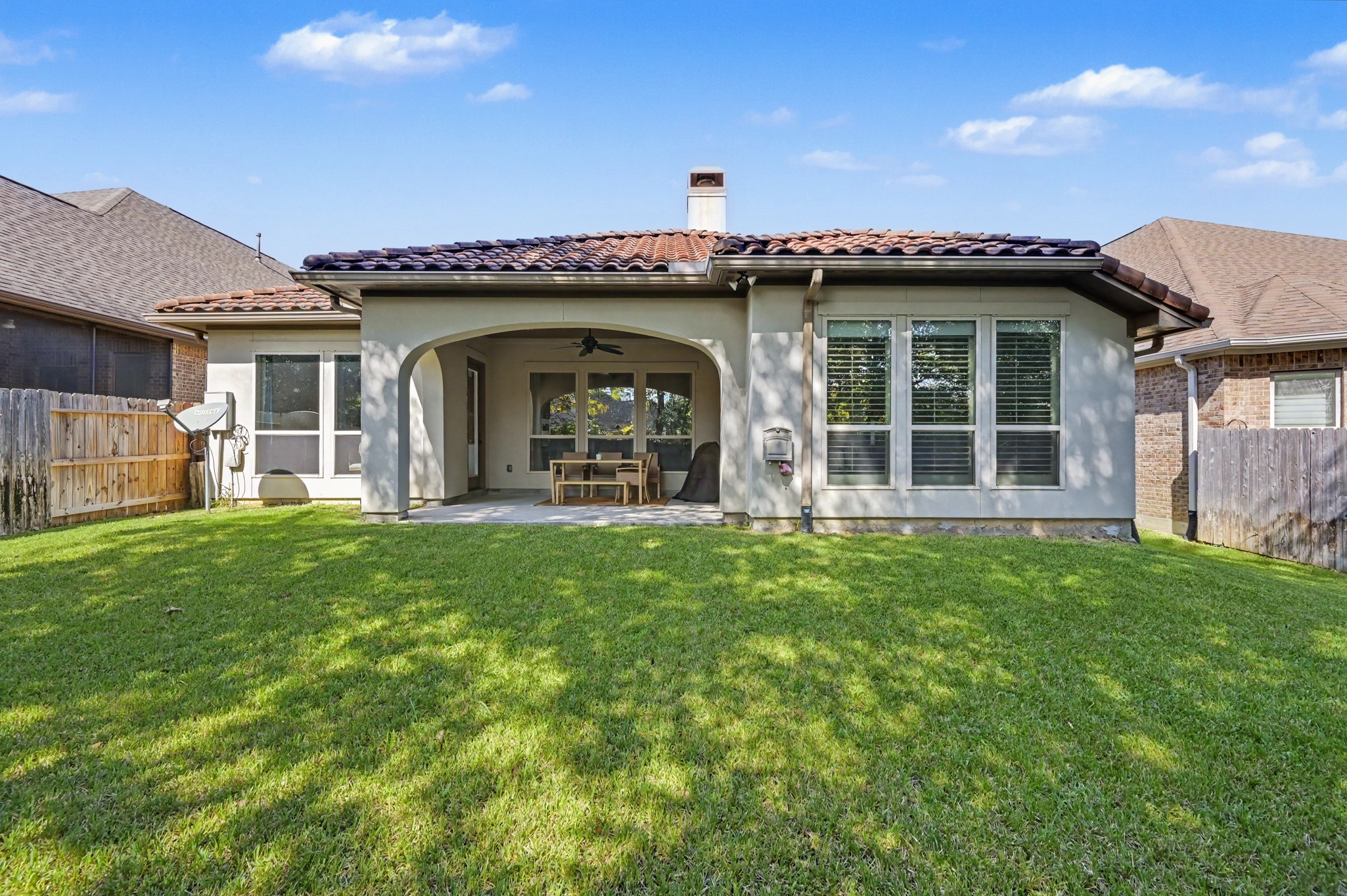 Charming backyard with a spacious covered patio, perfect for outdoor entertaining and relaxation, complemented by a well-maintained lawn.