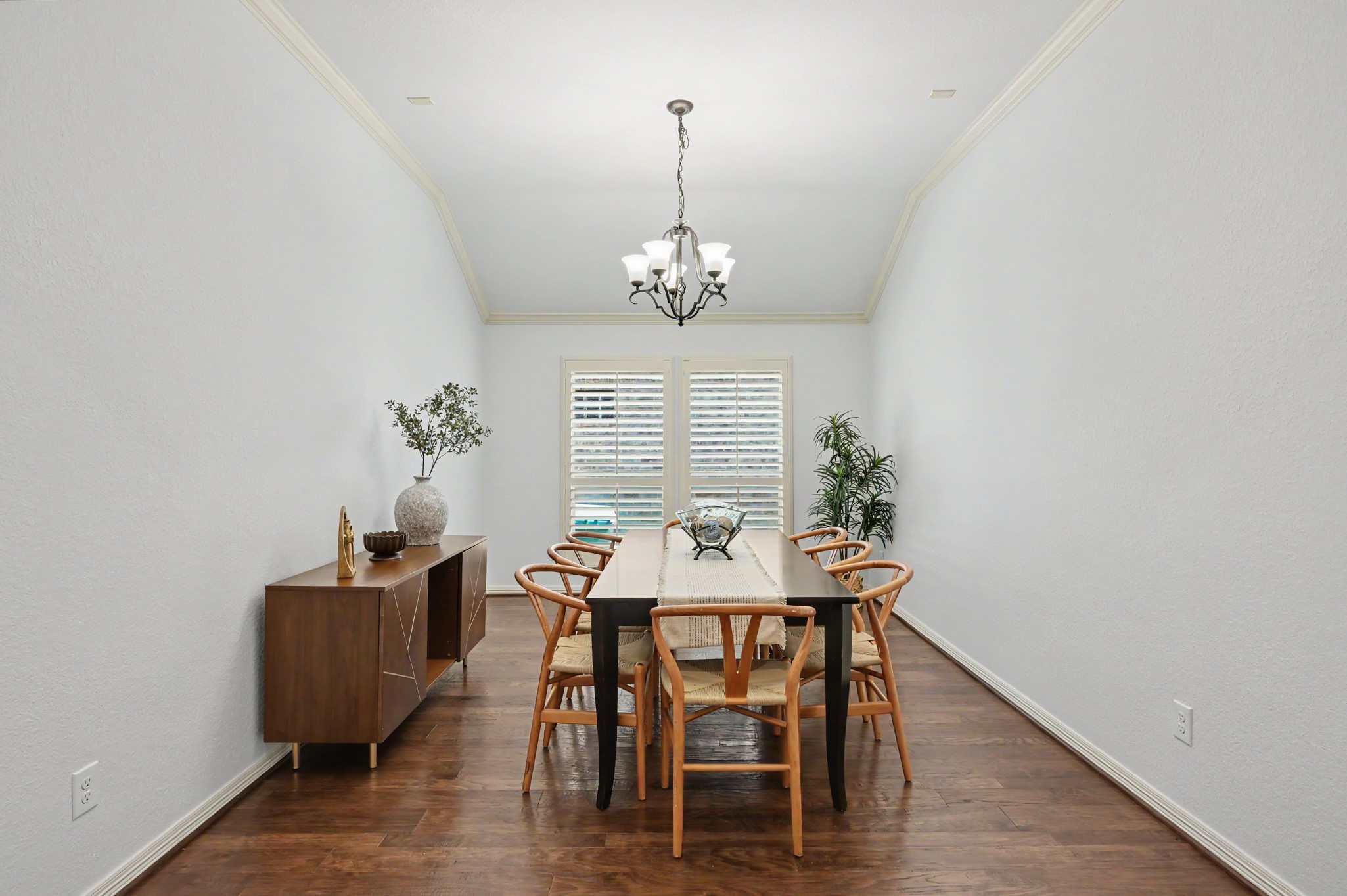 Elegant dining room with high ceilings, hardwood floors, and ample natural light, featuring a stylish chandelier and contemporary furniture.