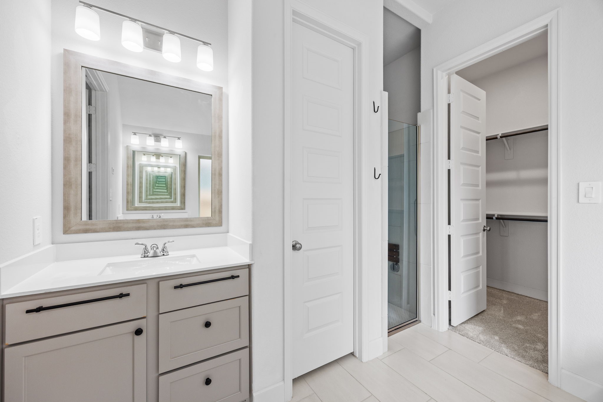 Spacious bathroom vanity with generous storage and convenient access to the adjoining walk-in closet.