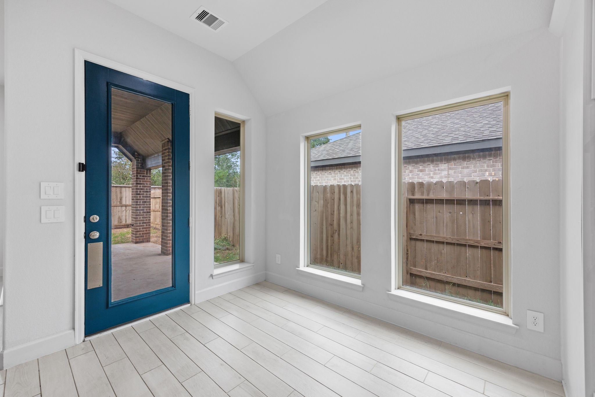 Charming breakfast area with expansive windows and a striking blue-framed glass door.