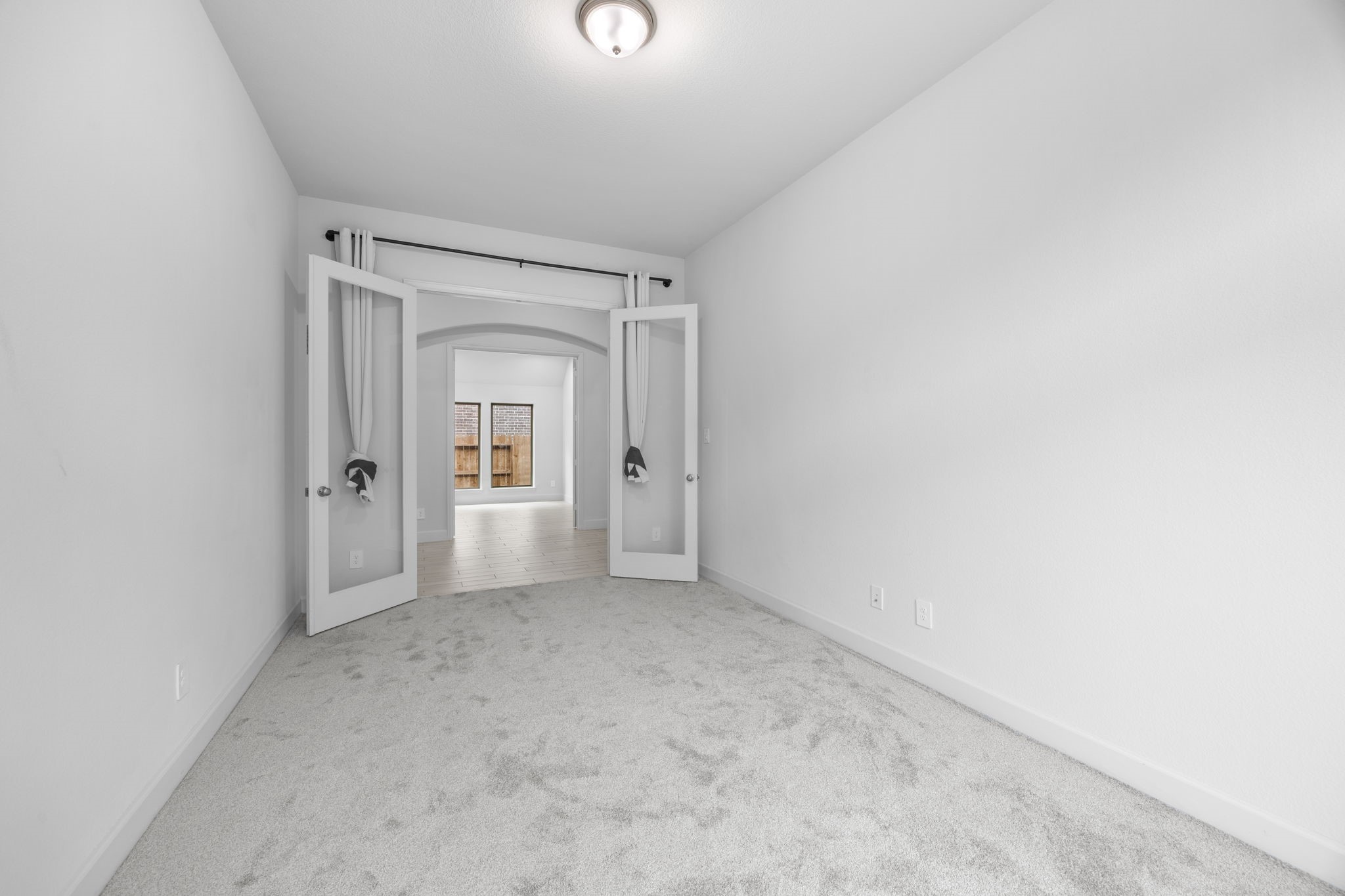 Generously sized bedroom with neutral finishes, soft carpeting, and an abundance of natural light.