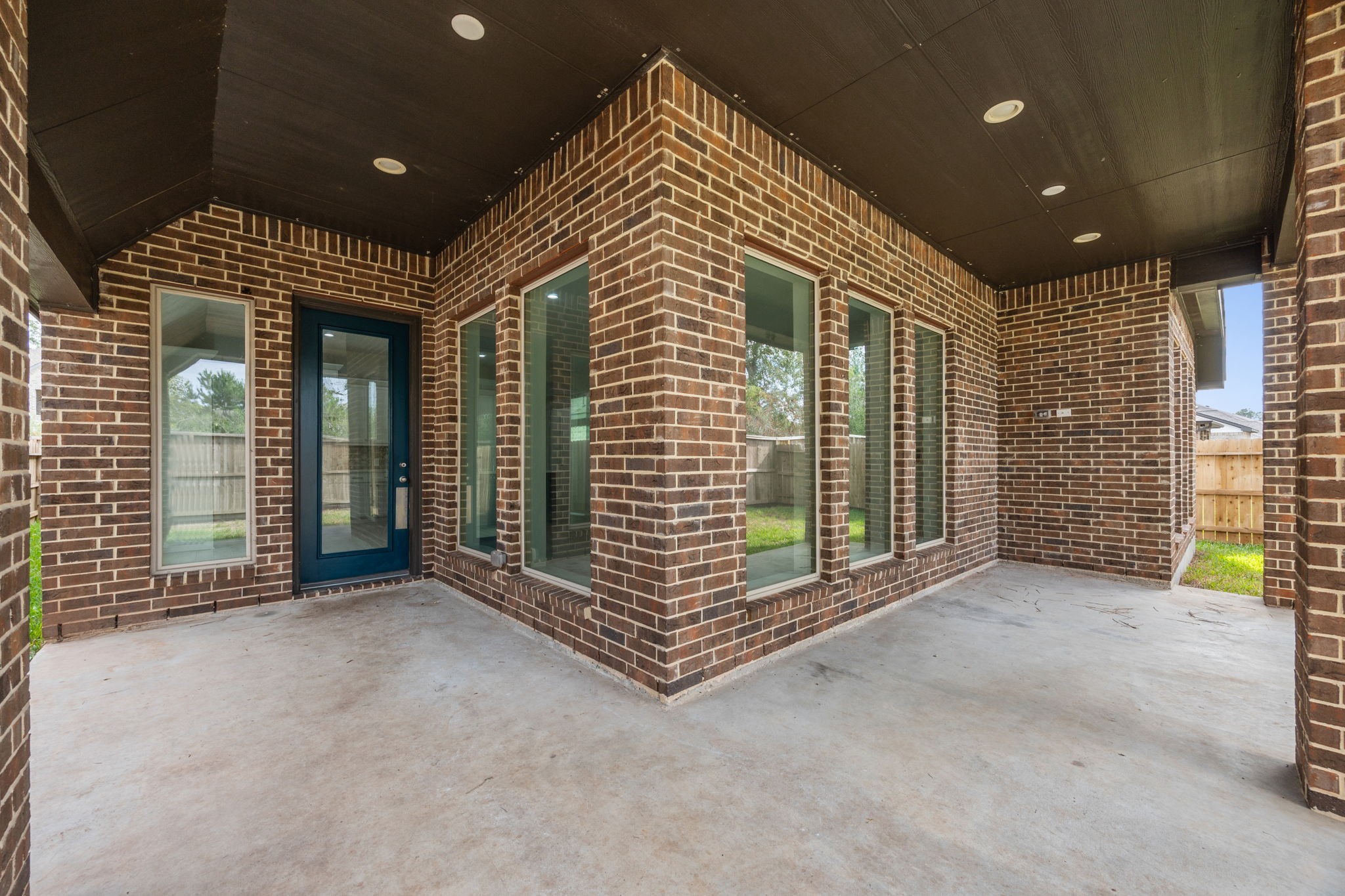 Inviting covered patio with a beautifully finished ceiling, recessed lighting, and plenty of space for outdoor entertaining.