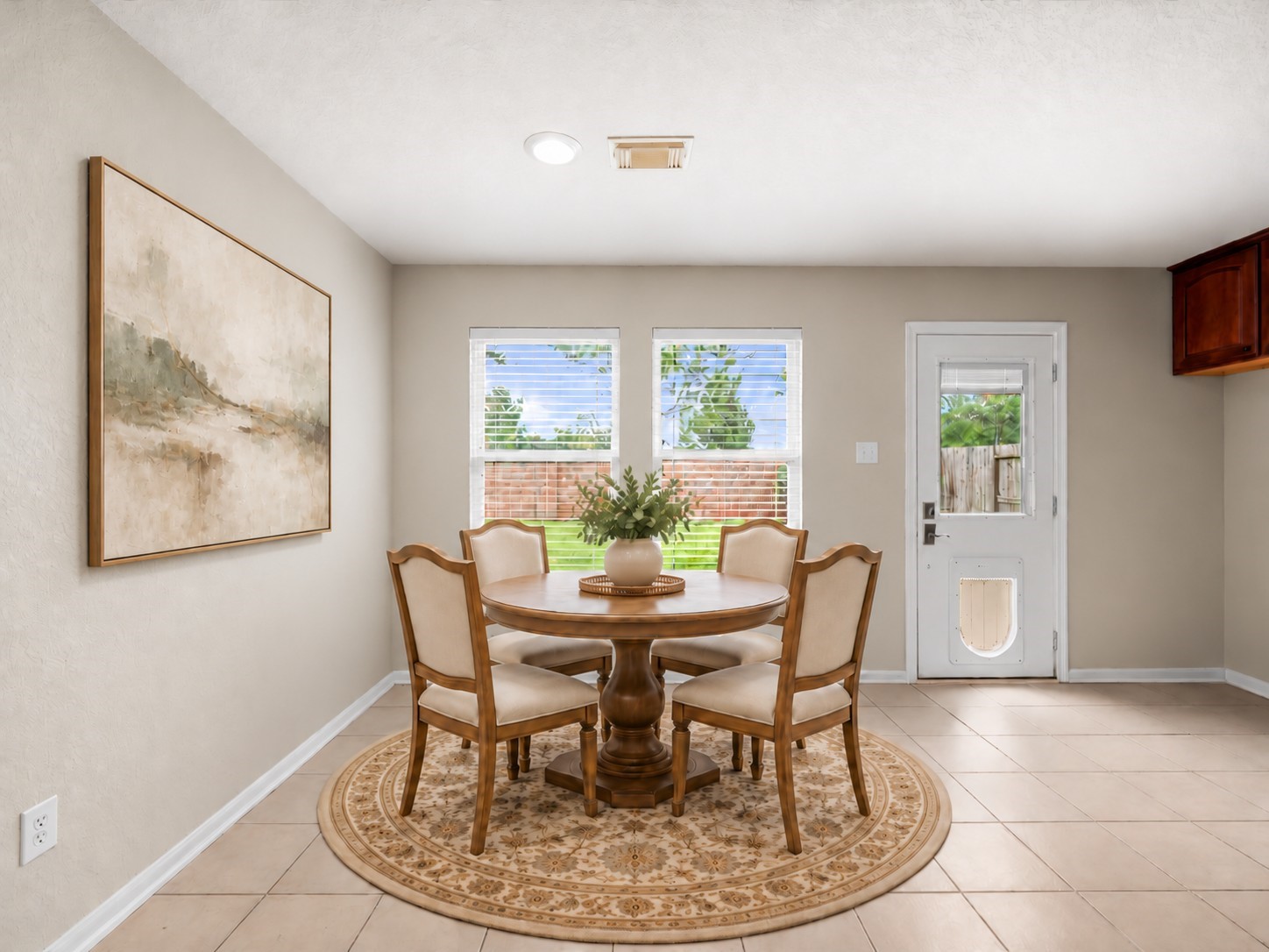 Furnishings have been virtually added to showcase the possibilities of this open-concept living area, where soaring ceilings, abundant natural light, and a cozy fireplace create a welcoming gathering space.