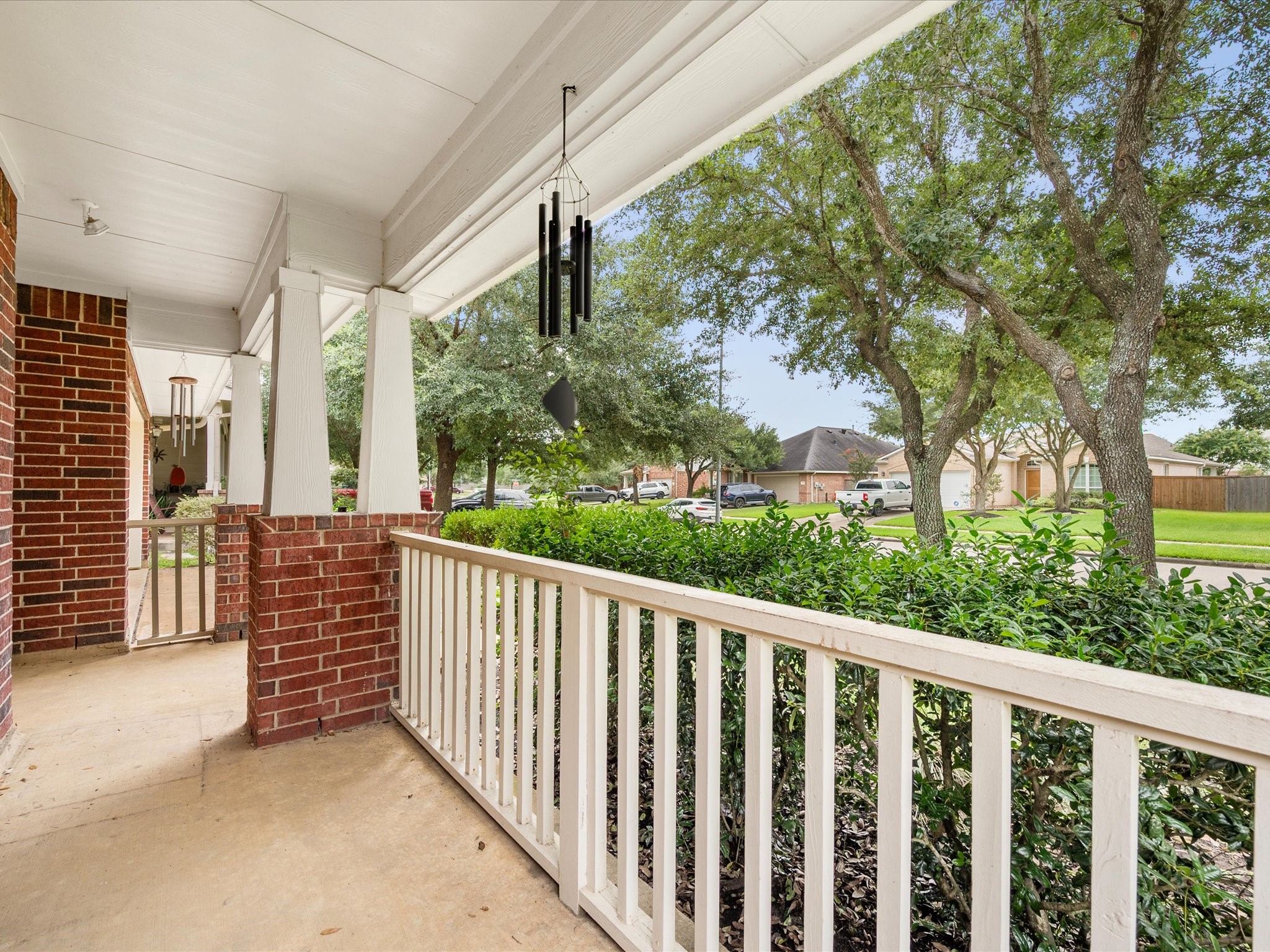 A welcoming front porch creates the perfect spot to enjoy morning coffee or unwind while taking in the beautifully established neighborhood surroundings.
