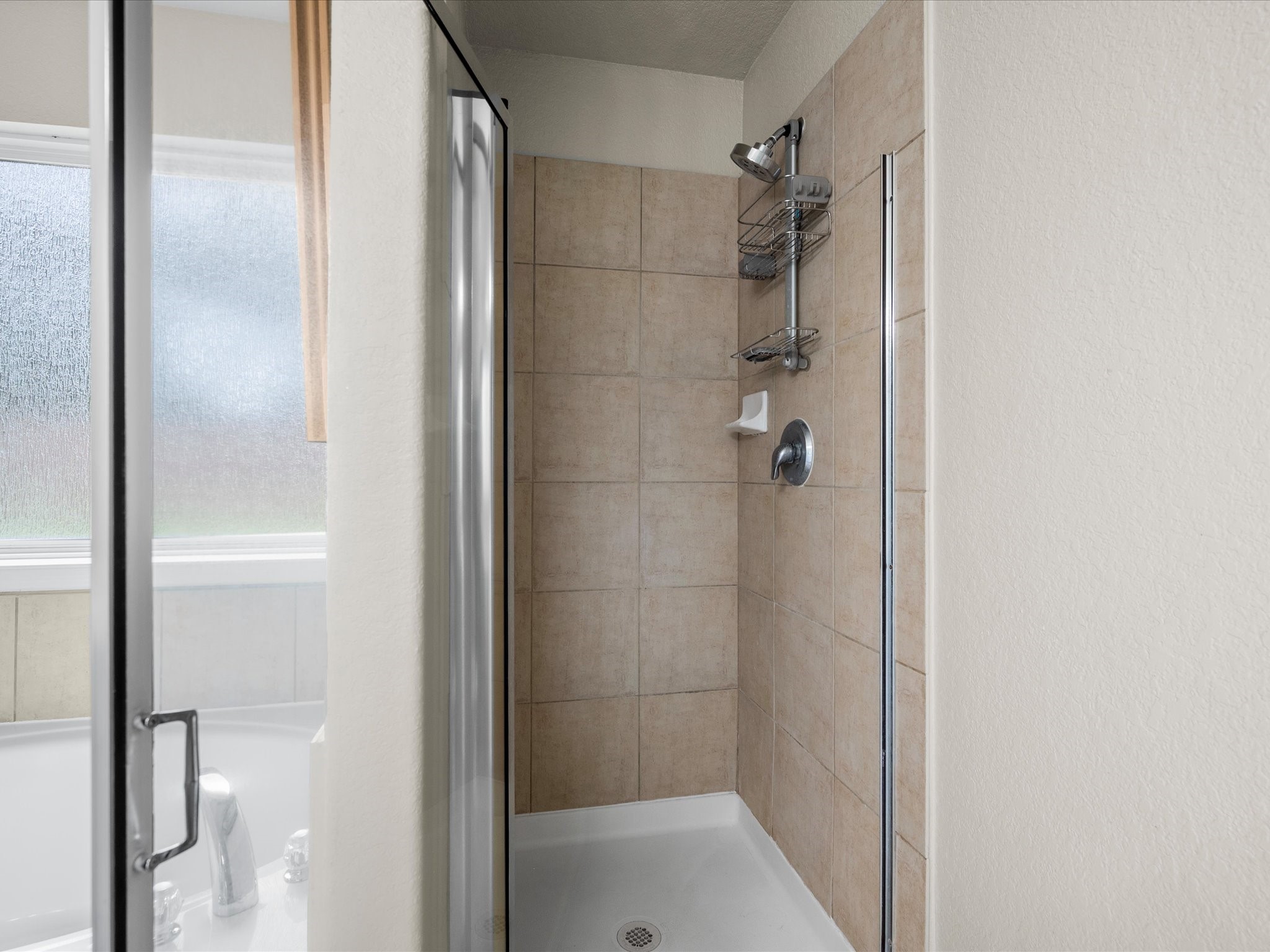 The primary bathroom offers added convenience with a separate shower, providing a functional and comfortable space to start and end each day.