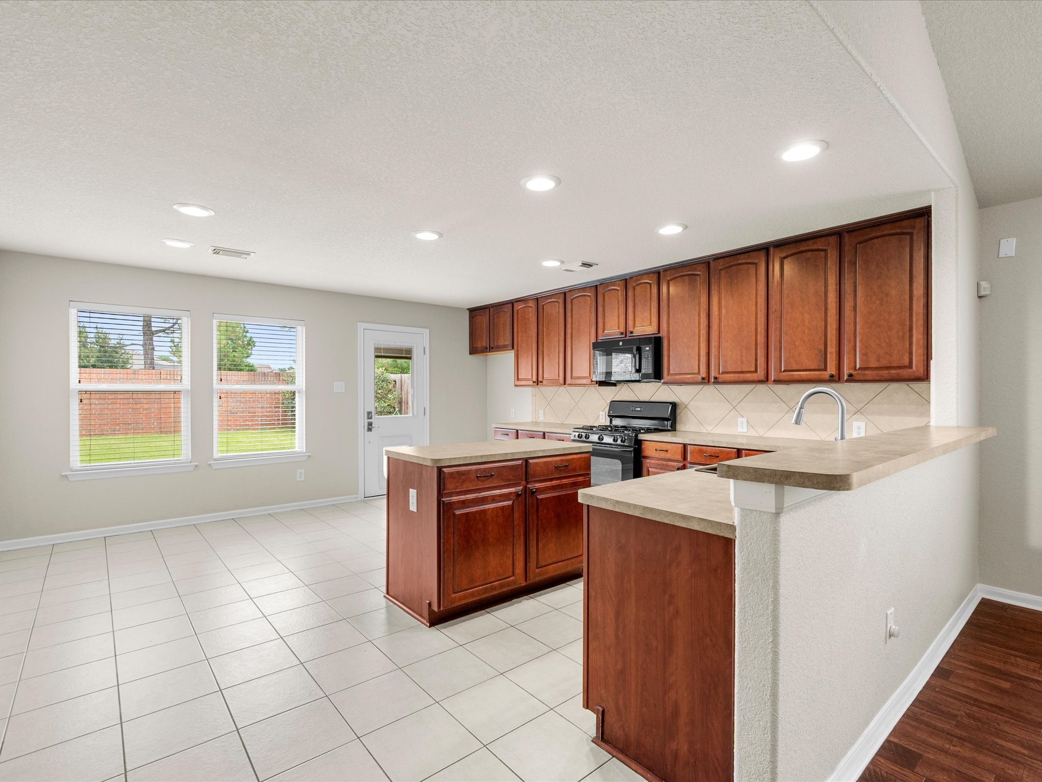 A generous kitchen island provides additional workspace and casual seating, while abundant cabinetry offers excellent storage and functionality.
