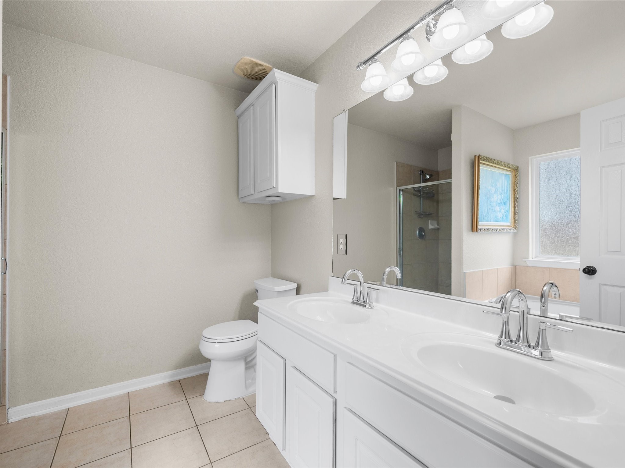 The private ensuite features a soaking tub, separate shower, updated sinks, and a spacious walk-in closet for added comfort and convenience.
