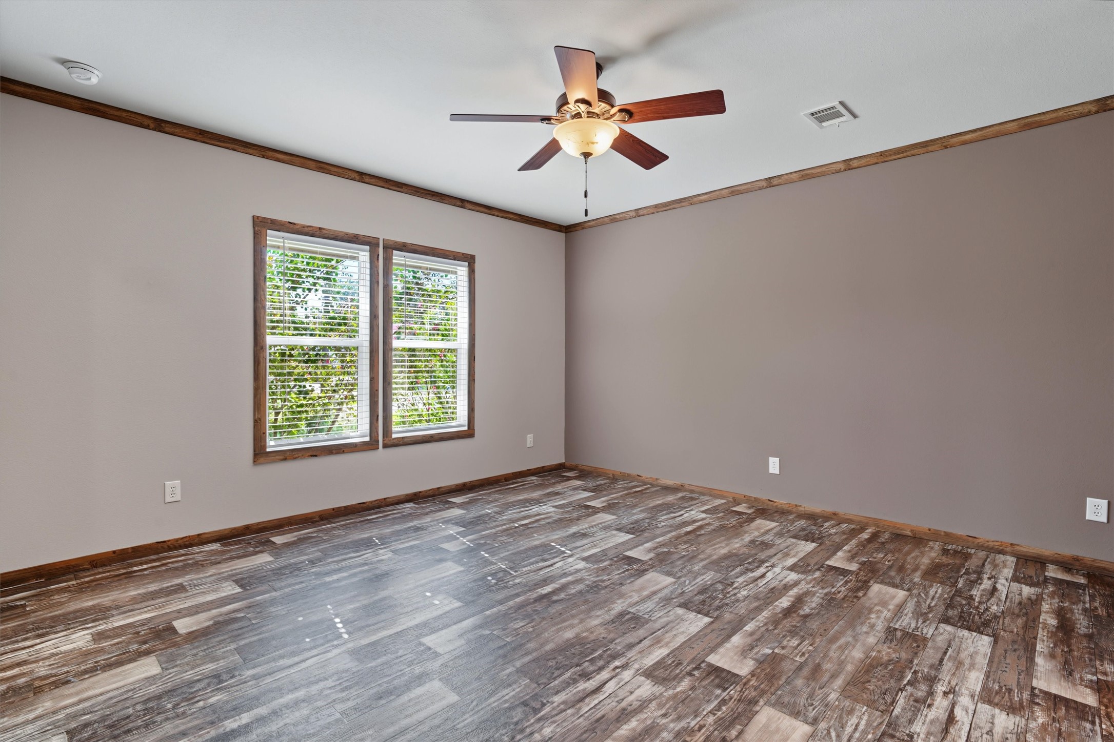 Oversized Primary Retreat  A spacious primary bedroom filled with natural light and enhanced by custom accent paint, creating a warm and inviting retreat to relax and unwind