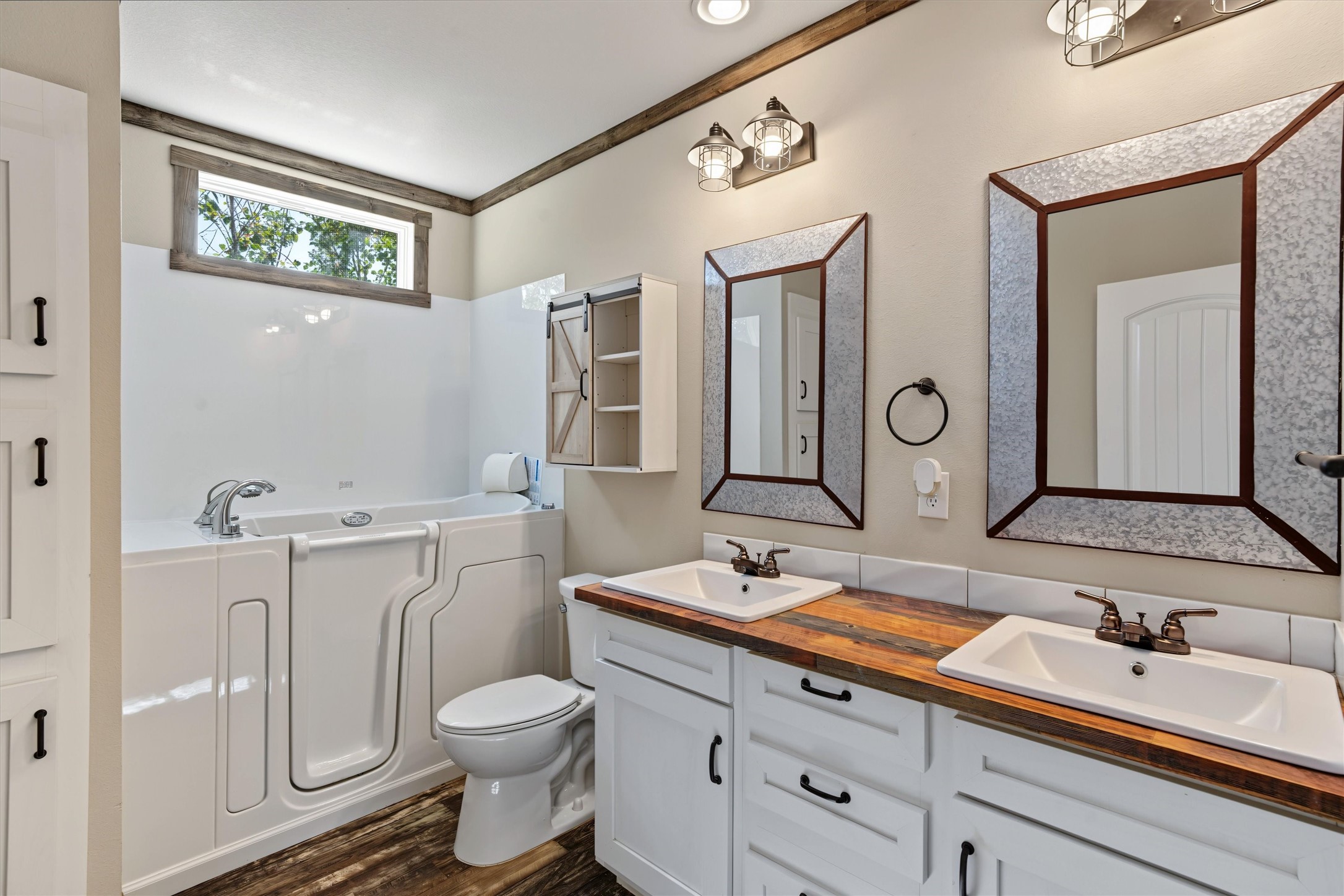 Spacious Guest Bathroom  Featuring a double-sink vanity and a handicap-accessible tub, this well-appointed bathroom offers comfort, convenience, and functionality