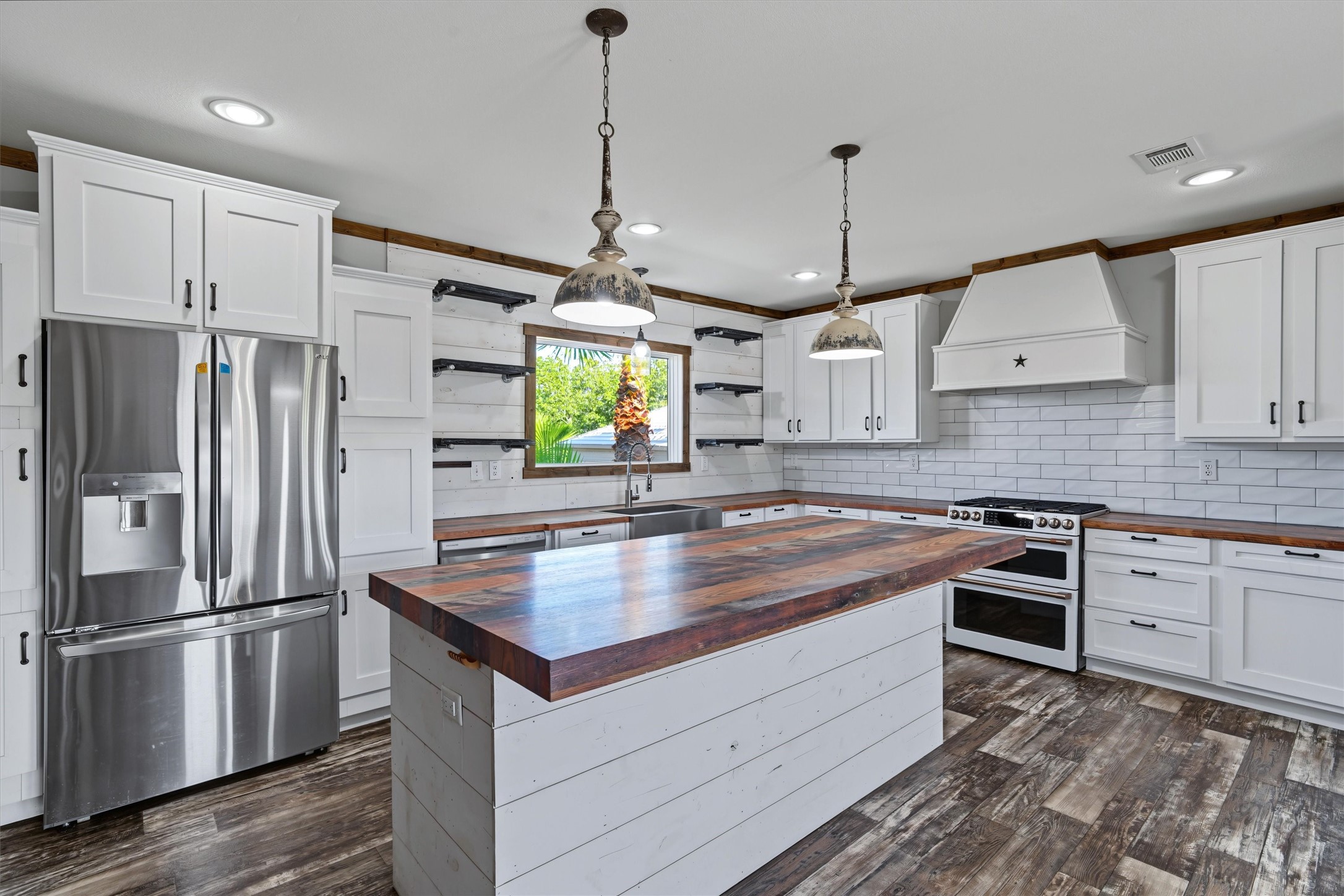 Oversized Island Kitchen  A spacious kitchen featuring a large center island, double oven, stainless-steel refrigerator, and matching stainless-steel appliances, offering plenty of room for cooking, gathering, and entertaining