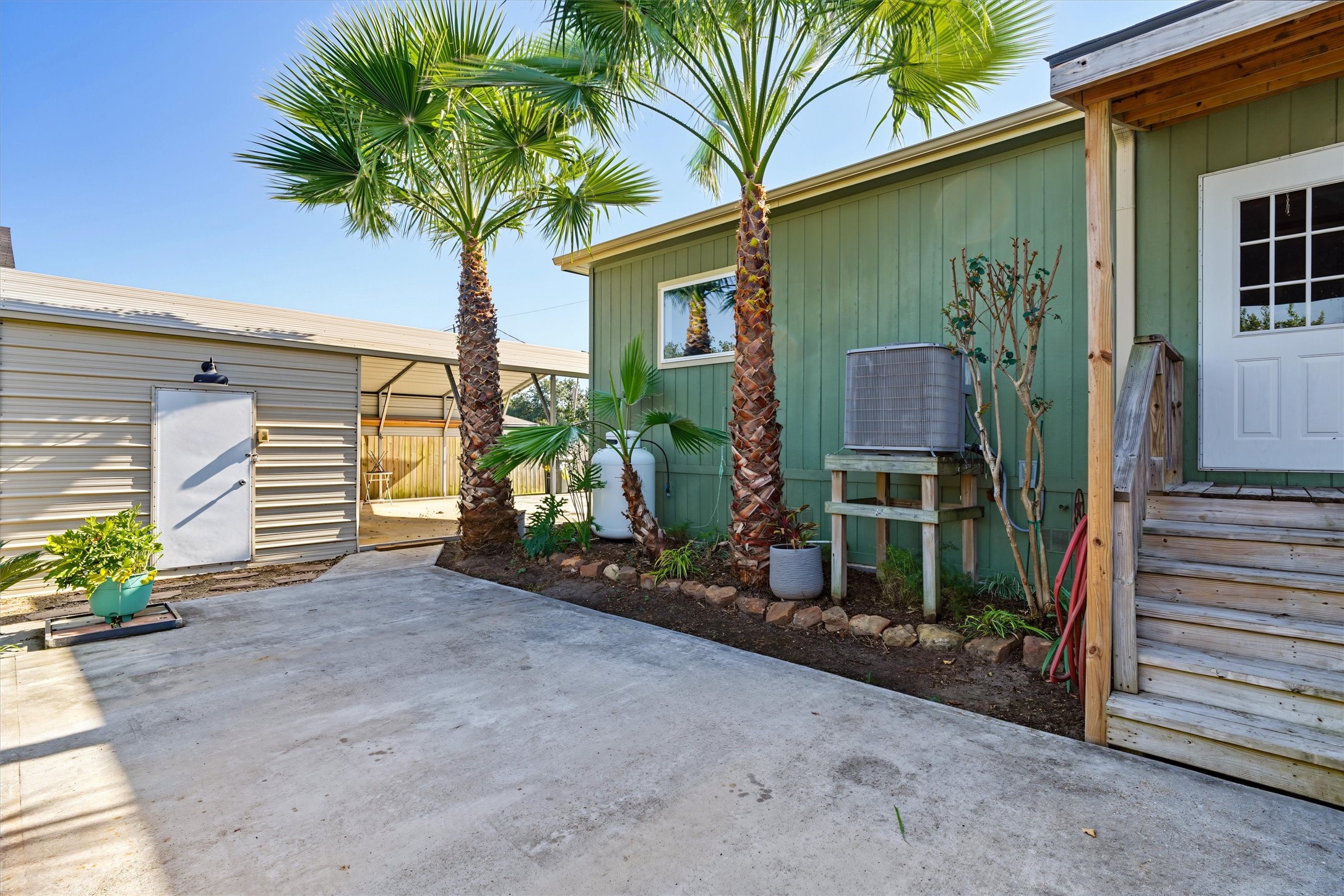 View of backyard patio, back door entering into the utility room, and the garage