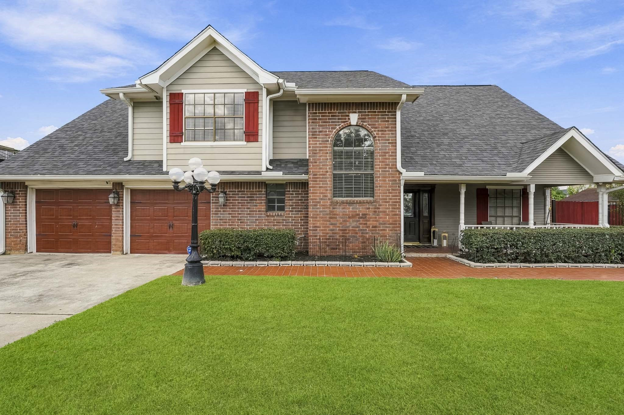 Charming two-story home with a classic brick facade, featuring a spacious two-car garage and inviting front porch. The well-maintained lawn and elegant lamp post enhance curb appeal. Charming two-story home with a classic brick facade, featuring a spacious two-car garage and inviting front porch. The well-maintained lawn and elegant lamp post enhance curb appeal.