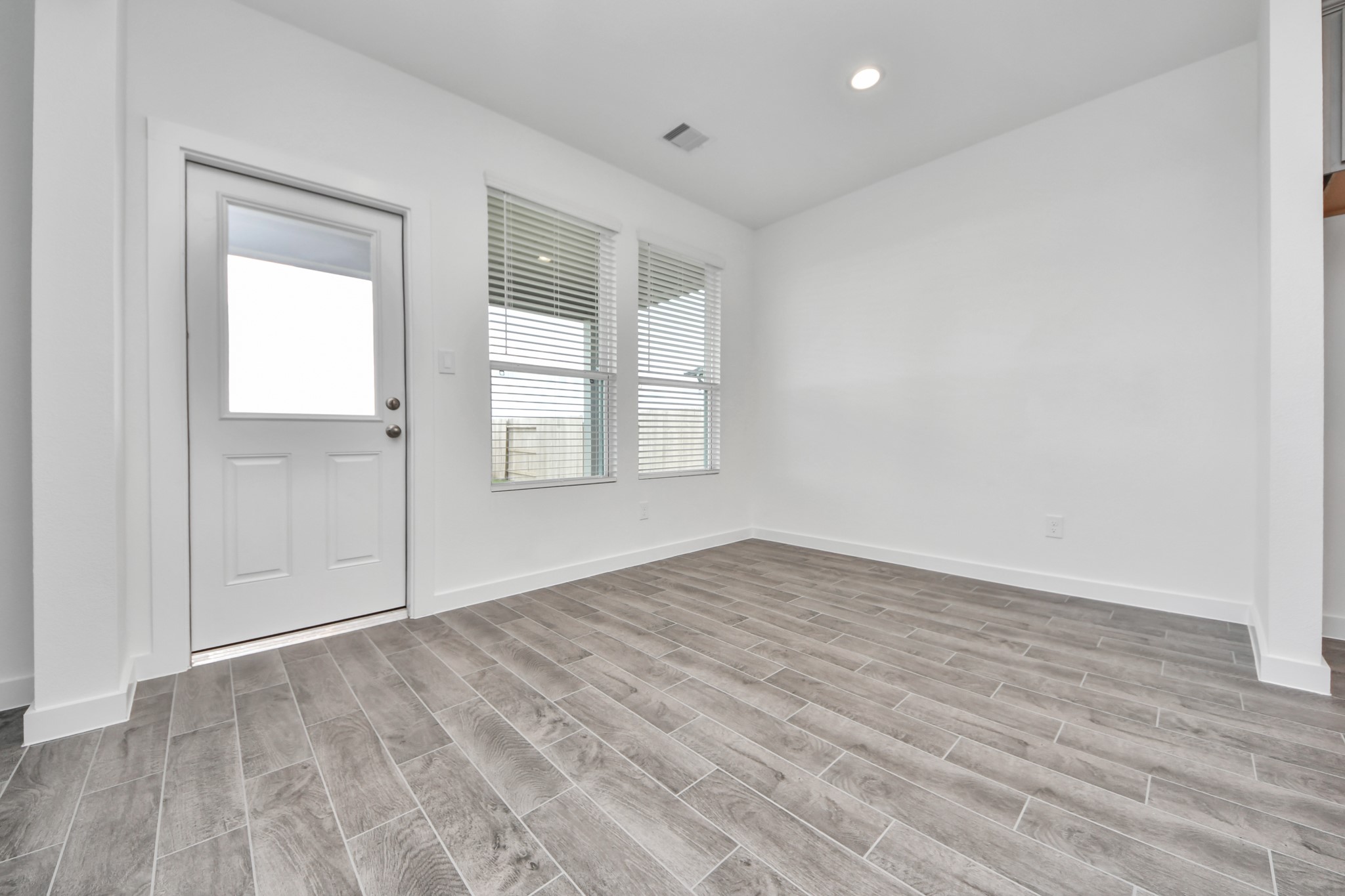 Welcome family and guests to your charming living room! With its high ceilings, recessed lighting, ceiling fan, custom paint, beautiful flooring, and large windows that let in abundant natural light, this room is perfect for gatherings. Sample photo of completed home with similar floor plan. Actual colors and selections may vary.