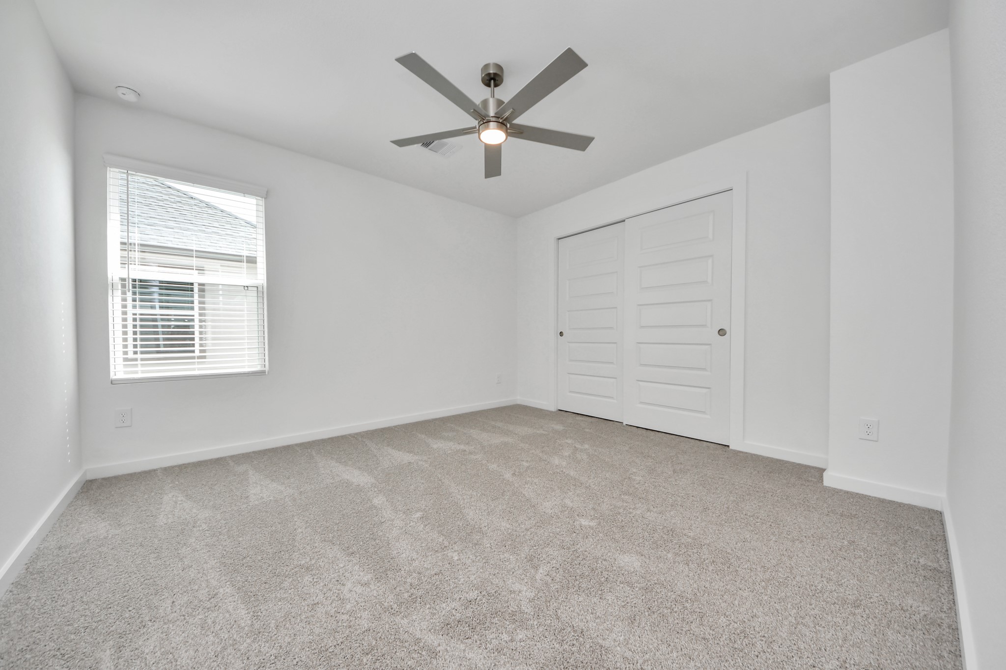 Secondary bedroom features plush carpeting, large windows that let in plenty of natural light, bright paint, and spacious closets. Sample photo of completed home with similar floor plan. Actual colors and selections may vary.
