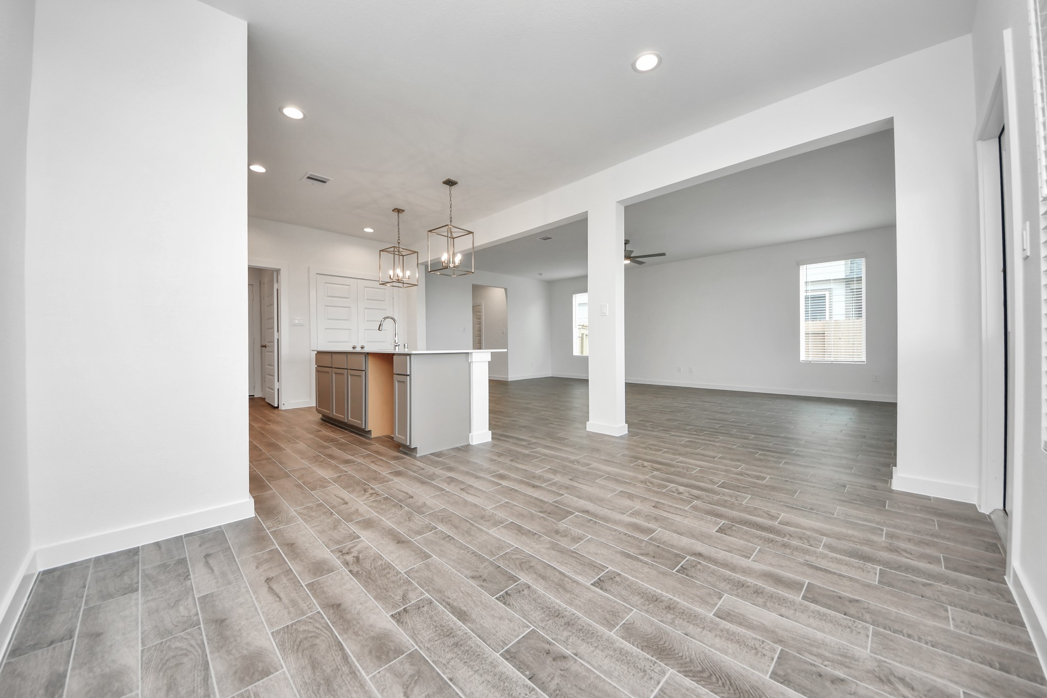 Gather the family and guests together in your lovely living room! Featuring soaring high ceilings, recessed lighting, ceiling fan, custom paint, gorgeous floors, and large windows that provide plenty of natural lighting throughout the day. Sample photo of completed home with similar floor plan. Actual colors and selections may vary.