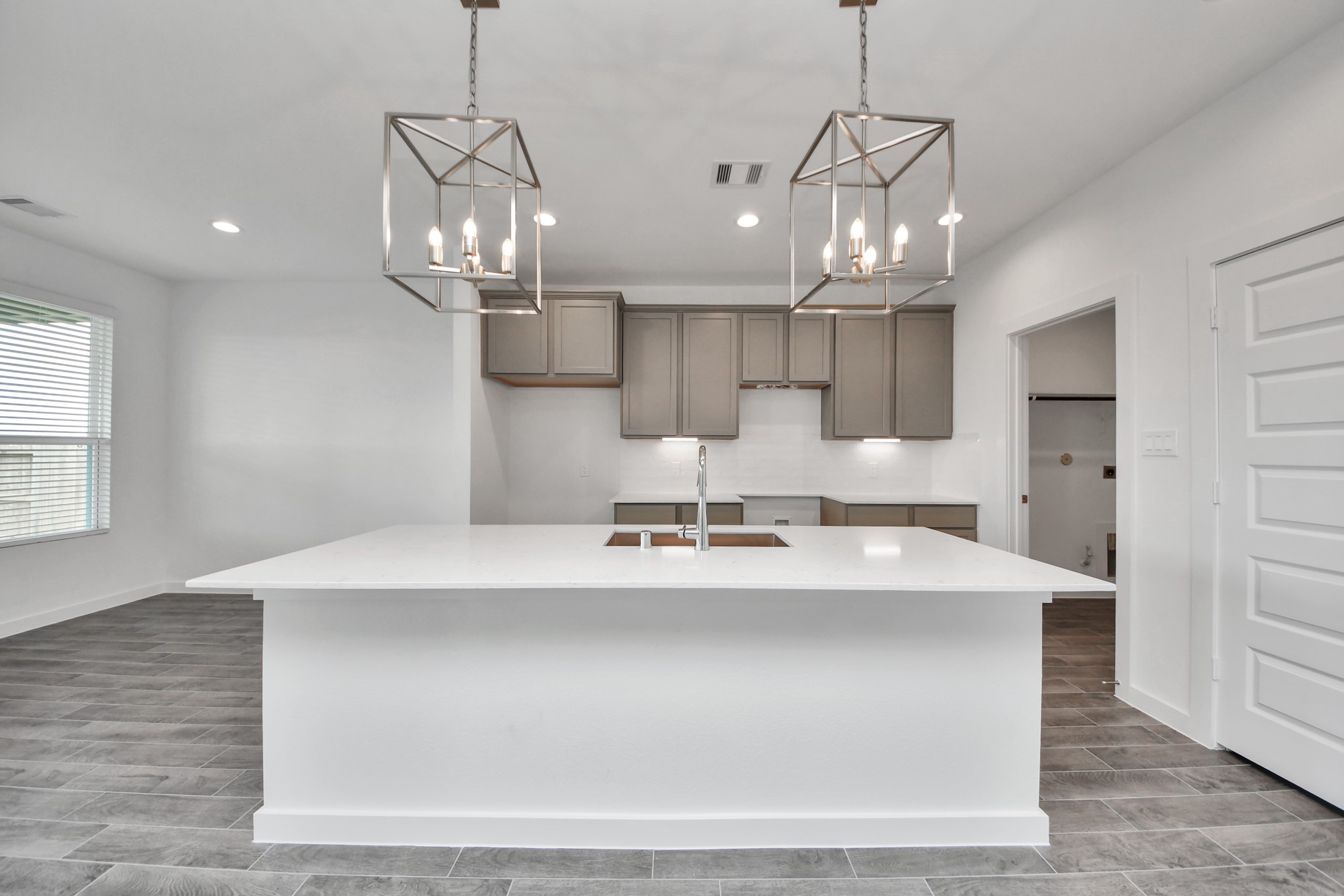 This kitchen is truly a chef's dream! This haven Boasts high ceilings, recessed & pendant lighting, stained wood cabinets, granite countertops, stainless steel appliances, a modern tile backsplash.  All of this overlooks your expansive family room, creating a perfect space for culinary delights and family gatherings. Sample photo of completed home with similar floor plan. Actual colors and selections may vary.