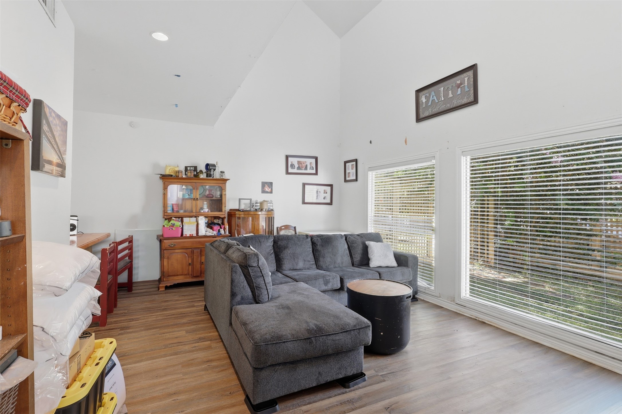Wall-to-wall picture windows frame peaceful backyard greenery, enhancing the dramatic scale of the soaring vaulted main space.