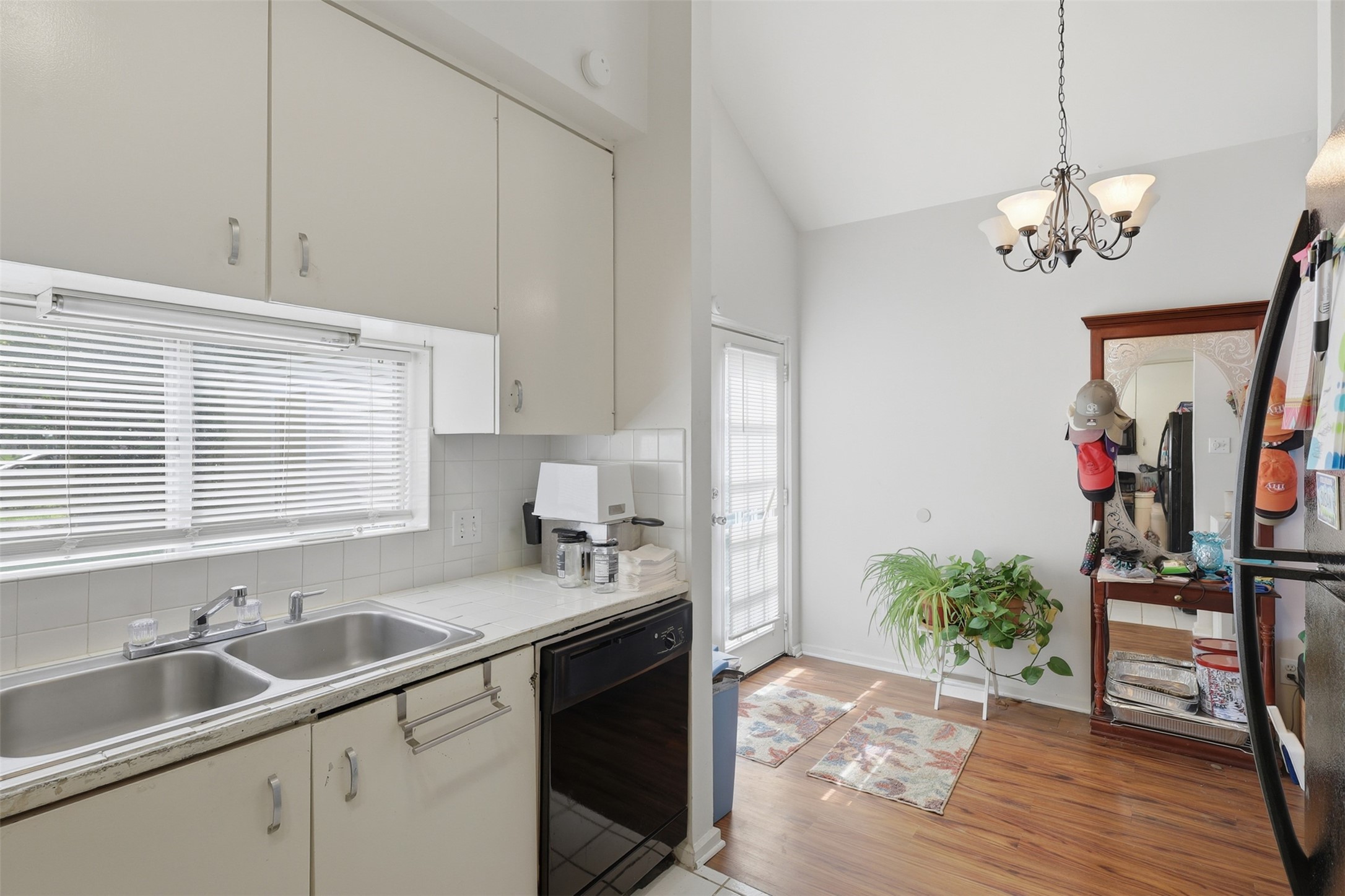 Natural light streams through the kitchen window directly into a versatile, high-ceiling breakfast nook perfect for morning coffee.