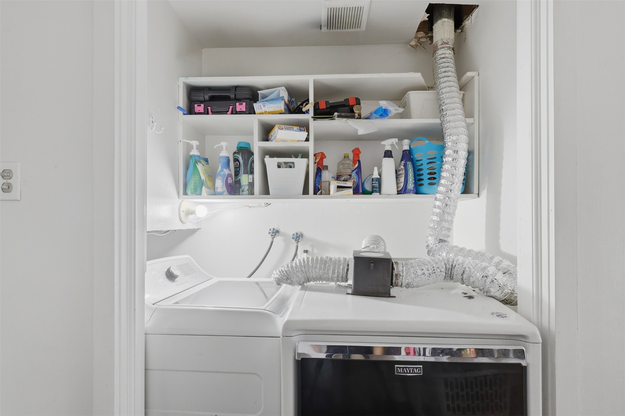 Dedicated indoor laundry station equipped with built-in multi-tier shelving to maximize organization and storage.
