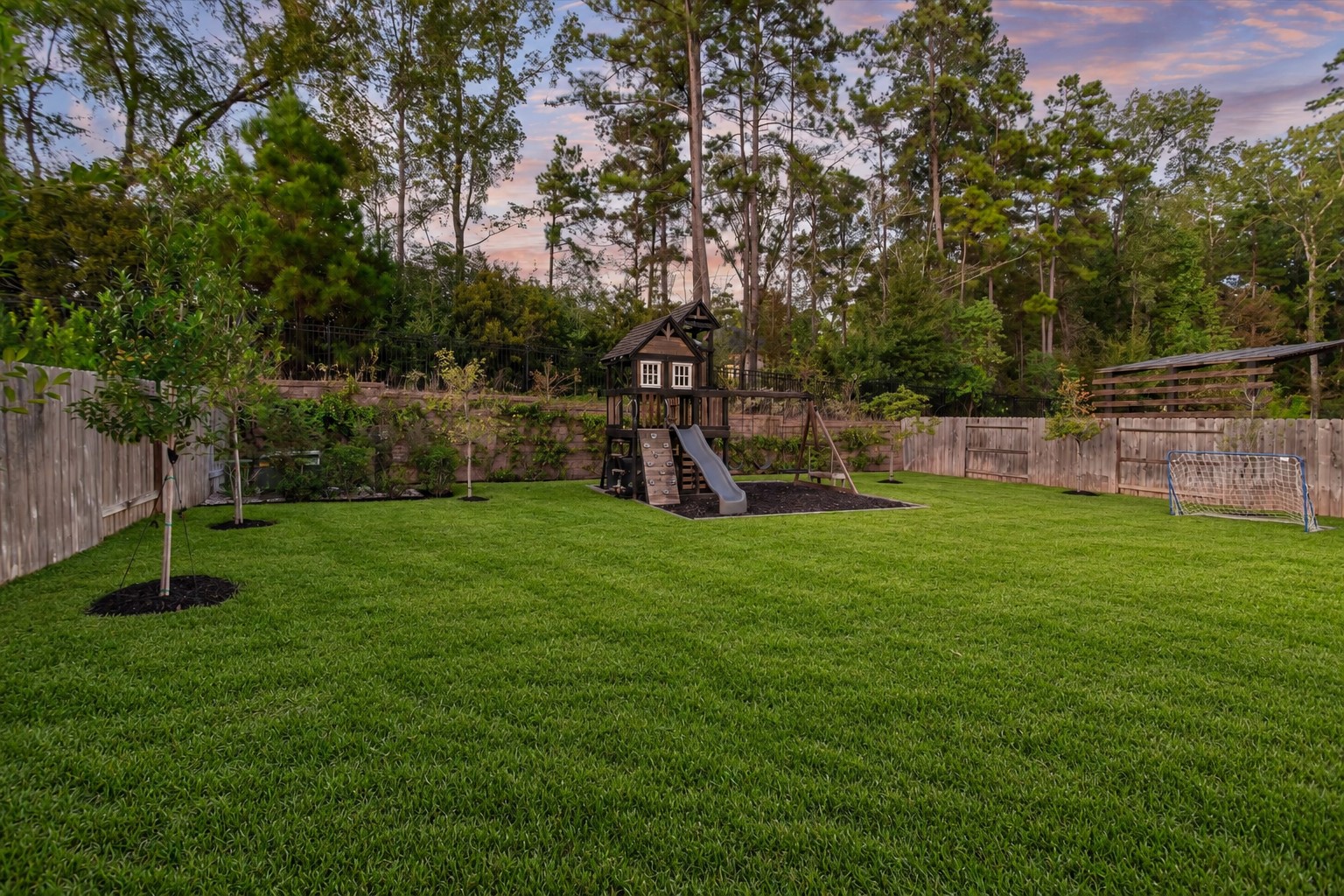 Experience ultimate privacy with no rear neighbors! A beautiful stone wall accented by elegant iron fencing frames the backyard, backing to lush, mature trees for a serene and secluded retreat.