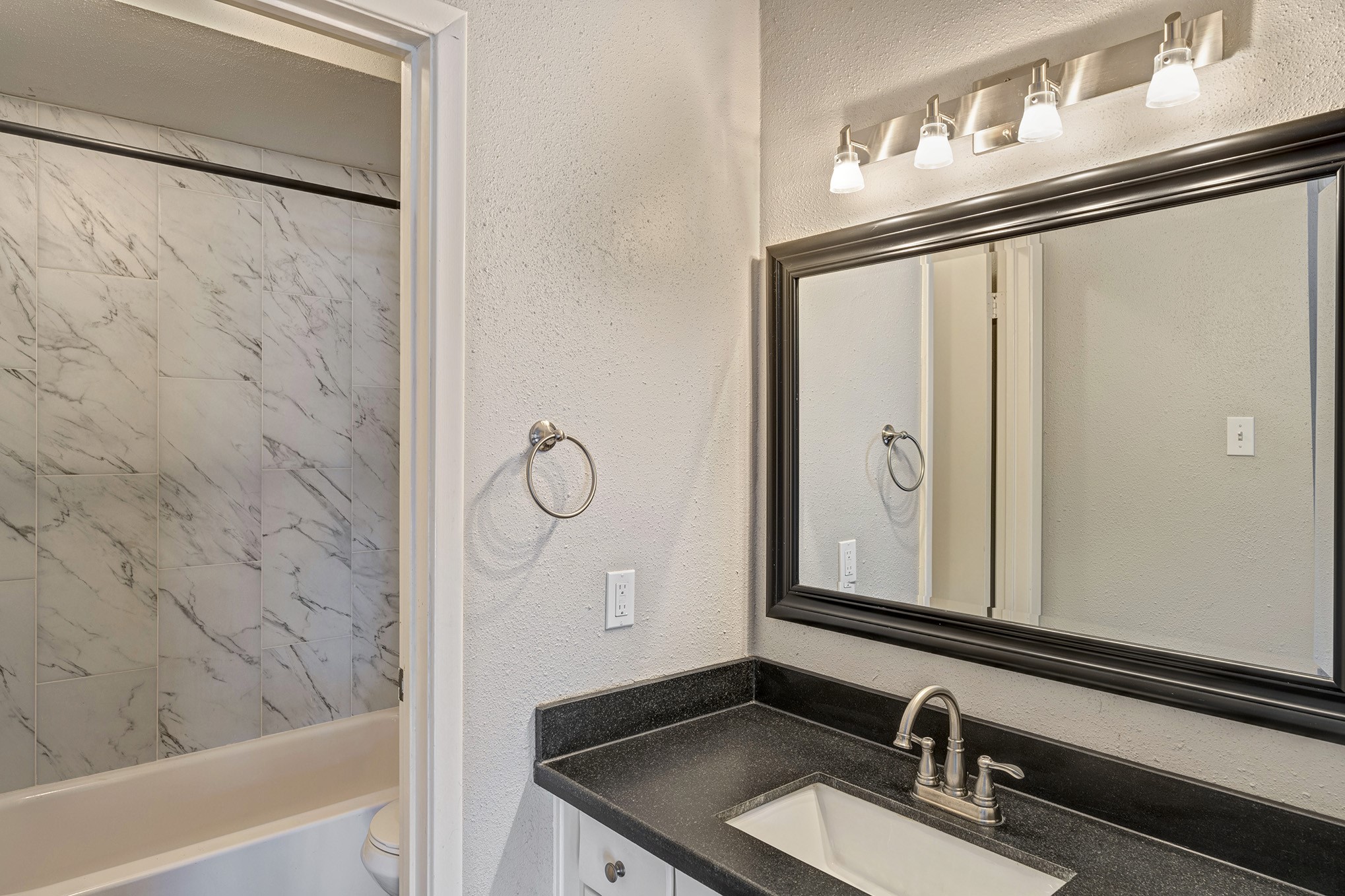 En suite bathroom with granite vanity and shower/tub.