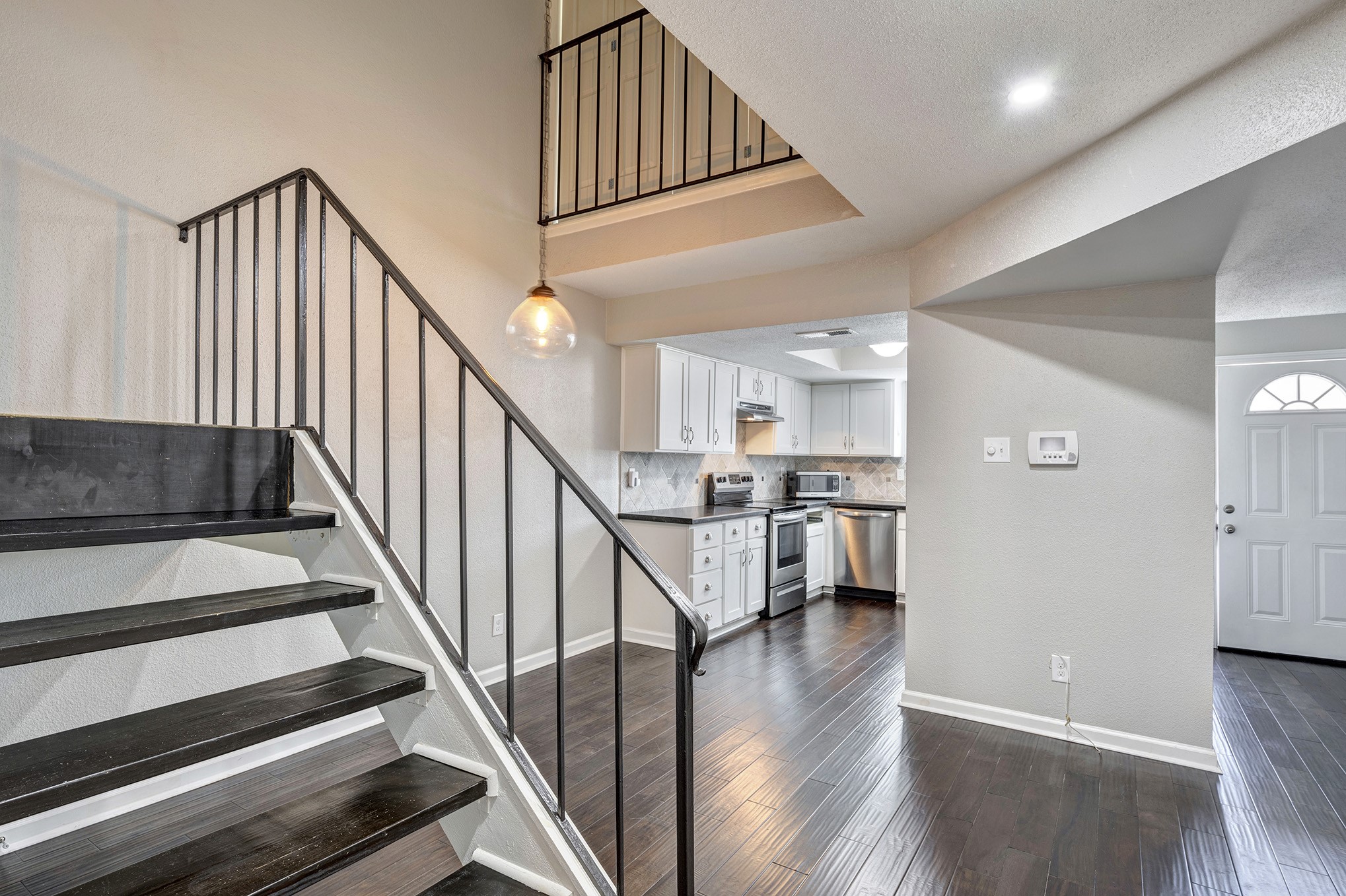 Great open floorplan with vaulted ceiling. View of staircase through dining to kitchen.