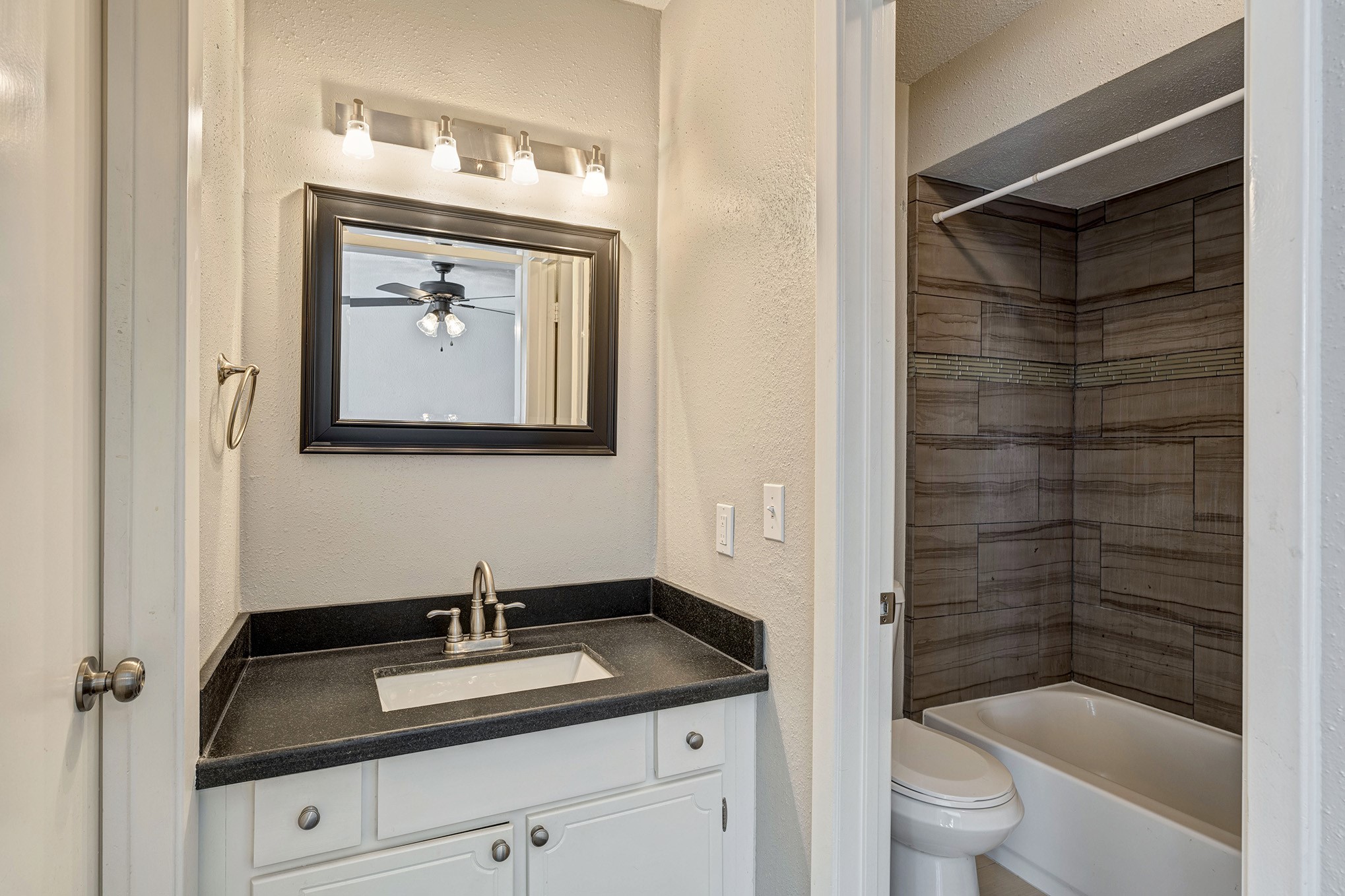 En suite bath for front bedroom has walk-in closet, granite vanity and shower/tub.