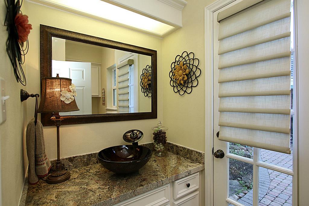 REMODELED POWDER BATH WITH VESSEL SINK OPENS TO BACKYARD. Powder bath has granite counters and vessel sink. Custom painted cabinets. Easy access to the backyard pool & spa, garage, laundry and kitchen area.