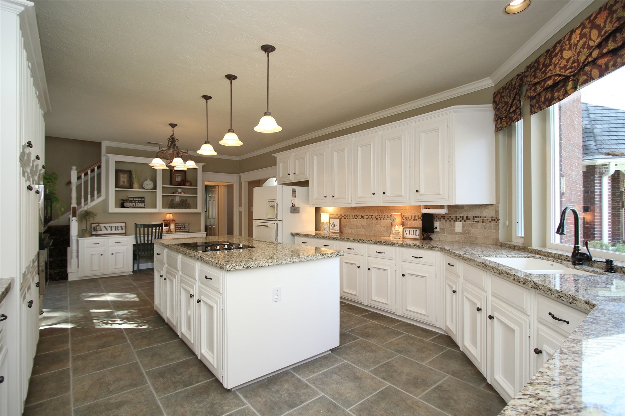 A CHEFS DREAM AT 25X14 WITH MORE THAN AMPLE CABINET SPACE AND LARGE ISLAND.   LARGE PICTURE WINDOW OVERLOOKING A TREMENDOUS BACK YARD POOL AND SPA.